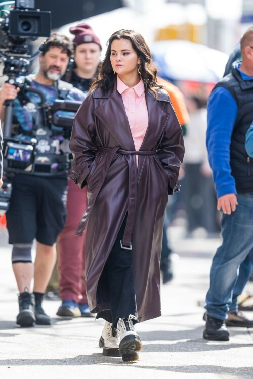 Selena Gomez On The Set in NYC - March 17 2023

Selena Gomez - ''Only Murderers in the Building'' set, NYC - March 17, 2023

Selena Gomez Wears Chic Oversized Plum Coat On 'Only Murders In the Building' Set

On Friday morning, Selena Gomez was photographed on the set of her hit Hulu show Only Murders In The Building in Queens, NY, with her co-stars Steve Martin and Martin Short. The singer and actress' look for the day included black denim pants peeking out from under an oversized dark purple trench coat by Olēnich. The statement piece made from faux leather featured large lapels and a belt cinching her in at the waist.

Under the coat was a pale pink button down and on her feet were a pair of white lace-up boots with a thick black sole.

Gomez left her long brunette hair down in waves and wore a pair of gold double hoop earrings. She had on a natural makeup palette for the shoot with a light coral lip.

On Only Murders in the Building, Gomez plays Mabel Mora, one of a trio of friends who are obsessed with true crime and who start a podcast together as they investigate a murder in their own apartment building. The show was renewed for a third season after receiving much critical acclaim, and has attracted lots of big guest stars like Tina Fey, Ryan Broussard, Jane Lynch, Meryl Streep, Ashley Park, and Paul Rudd.

The pop star told Deadline in an interview last year that when she was pitched the role, she was immediately excited to work with Martin and Short — and that the show's subject was of personal interest to her.

“They pitched me the idea and it led into a whole conversation about my actual obsession with true crime,” said Gomez. “I had just come back from CrimeCon when I had the call and it just felt like it was something I really wanted to do. They were all so lovely. And working with Steve and Marty would be a dream.”

ELLE/AIMÉE LUTKIN