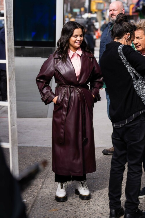 Selena Gomez On The Set in NYC - March 17 2023

Selena Gomez - ''Only Murderers in the Building'' set, NYC - March 17, 2023

Selena Gomez Wears Chic Oversized Plum Coat On 'Only Murders In the Building' Set

On Friday morning, Selena Gomez was photographed on the set of her hit Hulu show Only Murders In The Building in Queens, NY, with her co-stars Steve Martin and Martin Short. The singer and actress' look for the day included black denim pants peeking out from under an oversized dark purple trench coat by Olēnich. The statement piece made from faux leather featured large lapels and a belt cinching her in at the waist.

Under the coat was a pale pink button down and on her feet were a pair of white lace-up boots with a thick black sole.

Gomez left her long brunette hair down in waves and wore a pair of gold double hoop earrings. She had on a natural makeup palette for the shoot with a light coral lip.

On Only Murders in the Building, Gomez plays Mabel Mora, one of a trio of friends who are obsessed with true crime and who start a podcast together as they investigate a murder in their own apartment building. The show was renewed for a third season after receiving much critical acclaim, and has attracted lots of big guest stars like Tina Fey, Ryan Broussard, Jane Lynch, Meryl Streep, Ashley Park, and Paul Rudd.

The pop star told Deadline in an interview last year that when she was pitched the role, she was immediately excited to work with Martin and Short — and that the show's subject was of personal interest to her.

“They pitched me the idea and it led into a whole conversation about my actual obsession with true crime,” said Gomez. “I had just come back from CrimeCon when I had the call and it just felt like it was something I really wanted to do. They were all so lovely. And working with Steve and Marty would be a dream.”

ELLE/AIMÉE LUTKIN