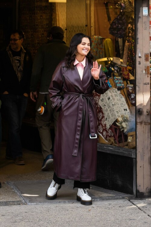 Selena Gomez On The Set in NYC - March 17 2023

Selena Gomez - ''Only Murderers in the Building'' set, NYC - March 17, 2023

Selena Gomez Wears Chic Oversized Plum Coat On 'Only Murders In the Building' Set

On Friday morning, Selena Gomez was photographed on the set of her hit Hulu show Only Murders In The Building in Queens, NY, with her co-stars Steve Martin and Martin Short. The singer and actress' look for the day included black denim pants peeking out from under an oversized dark purple trench coat by Olēnich. The statement piece made from faux leather featured large lapels and a belt cinching her in at the waist.

Under the coat was a pale pink button down and on her feet were a pair of white lace-up boots with a thick black sole.

Gomez left her long brunette hair down in waves and wore a pair of gold double hoop earrings. She had on a natural makeup palette for the shoot with a light coral lip.

On Only Murders in the Building, Gomez plays Mabel Mora, one of a trio of friends who are obsessed with true crime and who start a podcast together as they investigate a murder in their own apartment building. The show was renewed for a third season after receiving much critical acclaim, and has attracted lots of big guest stars like Tina Fey, Ryan Broussard, Jane Lynch, Meryl Streep, Ashley Park, and Paul Rudd.

The pop star told Deadline in an interview last year that when she was pitched the role, she was immediately excited to work with Martin and Short — and that the show's subject was of personal interest to her.

“They pitched me the idea and it led into a whole conversation about my actual obsession with true crime,” said Gomez. “I had just come back from CrimeCon when I had the call and it just felt like it was something I really wanted to do. They were all so lovely. And working with Steve and Marty would be a dream.”

ELLE/AIMÉE LUTKIN