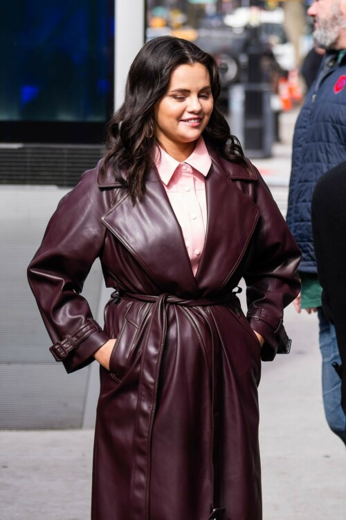 Selena Gomez On The Set in NYC - March 17 2023

Selena Gomez - ''Only Murderers in the Building'' set, NYC - March 17, 2023

Selena Gomez Wears Chic Oversized Plum Coat On 'Only Murders In the Building' Set

On Friday morning, Selena Gomez was photographed on the set of her hit Hulu show Only Murders In The Building in Queens, NY, with her co-stars Steve Martin and Martin Short. The singer and actress' look for the day included black denim pants peeking out from under an oversized dark purple trench coat by Olēnich. The statement piece made from faux leather featured large lapels and a belt cinching her in at the waist.

Under the coat was a pale pink button down and on her feet were a pair of white lace-up boots with a thick black sole.

Gomez left her long brunette hair down in waves and wore a pair of gold double hoop earrings. She had on a natural makeup palette for the shoot with a light coral lip.

On Only Murders in the Building, Gomez plays Mabel Mora, one of a trio of friends who are obsessed with true crime and who start a podcast together as they investigate a murder in their own apartment building. The show was renewed for a third season after receiving much critical acclaim, and has attracted lots of big guest stars like Tina Fey, Ryan Broussard, Jane Lynch, Meryl Streep, Ashley Park, and Paul Rudd.

The pop star told Deadline in an interview last year that when she was pitched the role, she was immediately excited to work with Martin and Short — and that the show's subject was of personal interest to her.

“They pitched me the idea and it led into a whole conversation about my actual obsession with true crime,” said Gomez. “I had just come back from CrimeCon when I had the call and it just felt like it was something I really wanted to do. They were all so lovely. And working with Steve and Marty would be a dream.”

ELLE/AIMÉE LUTKIN