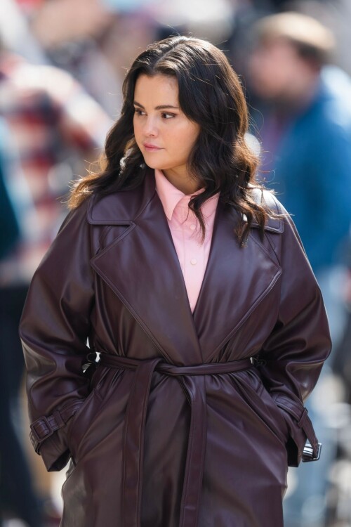 Selena Gomez - ''Only Murderers in the Building'' set, NYC - March 17, 2023

Selena Gomez Wears Chic Oversized Plum Coat On 'Only Murders In the Building' Set

On Friday morning, Selena Gomez was photographed on the set of her hit Hulu show Only Murders In The Building in Queens, NY, with her co-stars Steve Martin and Martin Short. The singer and actress' look for the day included black denim pants peeking out from under an oversized dark purple trench coat by Olēnich. The statement piece made from faux leather featured large lapels and a belt cinching her in at the waist.

Under the coat was a pale pink button down and on her feet were a pair of white lace-up boots with a thick black sole.

Gomez left her long brunette hair down in waves and wore a pair of gold double hoop earrings. She had on a natural makeup palette for the shoot with a light coral lip.

On Only Murders in the Building, Gomez plays Mabel Mora, one of a trio of friends who are obsessed with true crime and who start a podcast together as they investigate a murder in their own apartment building. The show was renewed for a third season after receiving much critical acclaim, and has attracted lots of big guest stars like Tina Fey, Ryan Broussard, Jane Lynch, Meryl Streep, Ashley Park, and Paul Rudd.

The pop star told Deadline in an interview last year that when she was pitched the role, she was immediately excited to work with Martin and Short — and that the show's subject was of personal interest to her.

“They pitched me the idea and it led into a whole conversation about my actual obsession with true crime,” said Gomez. “I had just come back from CrimeCon when I had the call and it just felt like it was something I really wanted to do. They were all so lovely. And working with Steve and Marty would be a dream.”

ELLE/AIMÉE LUTKIN