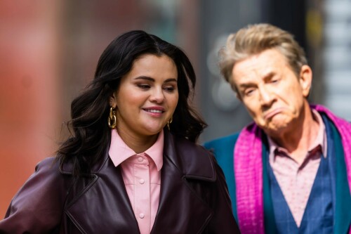 Selena Gomez On The Set in NYC - March 17 2023

Selena Gomez - ''Only Murderers in the Building'' set, NYC - March 17, 2023

Selena Gomez Wears Chic Oversized Plum Coat On 'Only Murders In the Building' Set

On Friday morning, Selena Gomez was photographed on the set of her hit Hulu show Only Murders In The Building in Queens, NY, with her co-stars Steve Martin and Martin Short. The singer and actress' look for the day included black denim pants peeking out from under an oversized dark purple trench coat by Olēnich. The statement piece made from faux leather featured large lapels and a belt cinching her in at the waist.

Under the coat was a pale pink button down and on her feet were a pair of white lace-up boots with a thick black sole.

Gomez left her long brunette hair down in waves and wore a pair of gold double hoop earrings. She had on a natural makeup palette for the shoot with a light coral lip.

On Only Murders in the Building, Gomez plays Mabel Mora, one of a trio of friends who are obsessed with true crime and who start a podcast together as they investigate a murder in their own apartment building. The show was renewed for a third season after receiving much critical acclaim, and has attracted lots of big guest stars like Tina Fey, Ryan Broussard, Jane Lynch, Meryl Streep, Ashley Park, and Paul Rudd.

The pop star told Deadline in an interview last year that when she was pitched the role, she was immediately excited to work with Martin and Short — and that the show's subject was of personal interest to her.

“They pitched me the idea and it led into a whole conversation about my actual obsession with true crime,” said Gomez. “I had just come back from CrimeCon when I had the call and it just felt like it was something I really wanted to do. They were all so lovely. And working with Steve and Marty would be a dream.”

ELLE/AIMÉE LUTKIN