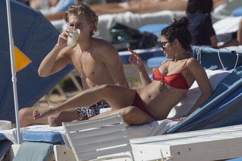 Back in each other's arms! Bikini-clad Vanessa Hudgens shares a steamy kiss with boyfriend Austin Butler as they are reunited in Hawaii

She's been promoting her latest movie Journey 2: The Mysterious Island, with her ex Josh Hutcherson and causing some confusion with the Australian press as to who's dating who.

But today, the bikini-clad 23-year-old was reunited with her current boyfriend Austin Butler in Hawaii, leaving onlookers with no doubt as to who has Vanessa 's heart now.

The couple, who have been dating since last September, are clearly very much in the honeymoon period of their relationship.

The High School Musical actress, who also dated co-star Zac Efron, looked stunning as she sported a tiny red string bikini in Hawaii.

She showed her athletic figure in the attire which she paired with some wooden-style jewellery accessories.

Vanessa and fellow Disney actor Austin, 20, frolicked in the ocean together, kissing and cuddling.

Their lovey-dovey behaviour akin to the last few weeks, with the couple just unable to keep their hands off each other.

When Vanessa and Austin started dating last year, friends said at the time that it was 'nothing serious', but the pair now seem to be inseparable.

They holidayed in Miami last month, visited Disneyland in Anaheim, California, and spent Christmas and New Year's together too.

Austin, who recently co-starred in the movie Sharpay's Fabulous Adventure, alongside Vanessa's best friend Ashley Tisdale, is three years younger than Vanessa.