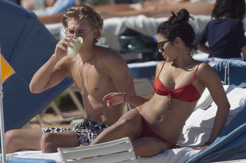 Back in each other's arms! Bikini-clad Vanessa Hudgens shares a steamy kiss with boyfriend Austin Butler as they are reunited in Hawaii

She's been promoting her latest movie Journey 2: The Mysterious Island, with her ex Josh Hutcherson and causing some confusion with the Australian press as to who's dating who.

But today, the bikini-clad 23-year-old was reunited with her current boyfriend Austin Butler in Hawaii, leaving onlookers with no doubt as to who has Vanessa 's heart now.

The couple, who have been dating since last September, are clearly very much in the honeymoon period of their relationship.

The High School Musical actress, who also dated co-star Zac Efron, looked stunning as she sported a tiny red string bikini in Hawaii.

She showed her athletic figure in the attire which she paired with some wooden-style jewellery accessories.

Vanessa and fellow Disney actor Austin, 20, frolicked in the ocean together, kissing and cuddling.

Their lovey-dovey behaviour akin to the last few weeks, with the couple just unable to keep their hands off each other.

When Vanessa and Austin started dating last year, friends said at the time that it was 'nothing serious', but the pair now seem to be inseparable.

They holidayed in Miami last month, visited Disneyland in Anaheim, California, and spent Christmas and New Year's together too.

Austin, who recently co-starred in the movie Sharpay's Fabulous Adventure, alongside Vanessa's best friend Ashley Tisdale, is three years younger than Vanessa.