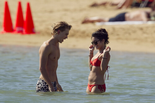 Back in each other's arms! Bikini-clad Vanessa Hudgens shares a steamy kiss with boyfriend Austin Butler as they are reunited in Hawaii

She's been promoting her latest movie Journey 2: The Mysterious Island, with her ex Josh Hutcherson and causing some confusion with the Australian press as to who's dating who.

But today, the bikini-clad 23-year-old was reunited with her current boyfriend Austin Butler in Hawaii, leaving onlookers with no doubt as to who has Vanessa 's heart now.

The couple, who have been dating since last September, are clearly very much in the honeymoon period of their relationship.

The High School Musical actress, who also dated co-star Zac Efron, looked stunning as she sported a tiny red string bikini in Hawaii.

She showed her athletic figure in the attire which she paired with some wooden-style jewellery accessories.

Vanessa and fellow Disney actor Austin, 20, frolicked in the ocean together, kissing and cuddling.

Their lovey-dovey behaviour akin to the last few weeks, with the couple just unable to keep their hands off each other.

When Vanessa and Austin started dating last year, friends said at the time that it was 'nothing serious', but the pair now seem to be inseparable.

They holidayed in Miami last month, visited Disneyland in Anaheim, California, and spent Christmas and New Year's together too.

Austin, who recently co-starred in the movie Sharpay's Fabulous Adventure, alongside Vanessa's best friend Ashley Tisdale, is three years younger than Vanessa.