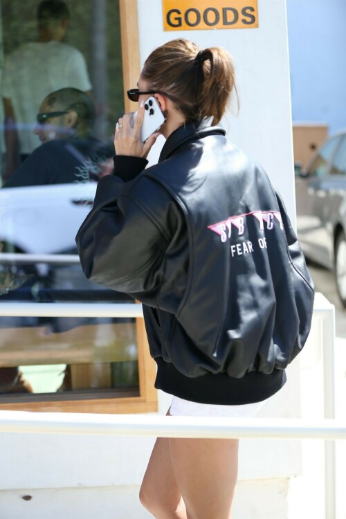 Hailey Bieber Embraces Lux Leather With Oversized Jacket & Metallic Nike Sneakers

Hailey Bieber was spotted grabbing a matcha drink while out in Los Angeles on Tuesday.

The 26-year-old model was photographed wearing a black waffle knit t-shirt underneath a black leather bomber jacket. She paired the top with white short shorts.

Bieber accessorized the neutral look with minimal jewelry opting solely for a pair of sparkling mini-gold hoops. She also added black vintage-style oval sunglasses. The model kept her warm blond hair in a sleek pulled-back style complimenting her minimal makeup that featured a mauve lip.

The Tiffany & Co. ambassador completed the look by slipping into a pair of white ankle socks and silver Nike Air Max sneakers. The metallic sneakers featured a wavy side paneled look with a beige tone lining the back of the chunky white sole and a black mesh encompassing the lace-up closure which was also decorated with a crisscross cord design.

The sneakers had a reflective finish completed with Nike’s Air cushioning to provide a lightweight experience The sneakers were designed by Sergio Lozano who pulled inspiration from retro athleisure wear from the 90s.

Bieber was just seen wearing these shoes while out in West Hollywood, Calif., earlier this week. During the recent sighting, the model embraced Y2K style as she paired the low-top sneakers with an oversized Martine Rose colorblock sports jacket and a distressed denim micro-mini skirt.

The model is known for her effortlessly chic style. When she’s spending a casual day to herself, you will usually see Bieber wearing a pair of sneakers or furry designer slides. If she’s making a red carpet appearance, Bieber is usually seen in textured pumps or strappy heels. Her shoe closet is filled with affordable sneakers from Nike, New Balance, or Reebok and luxury styles from Tabitha Simmons, Jimmy Choo and Prada.