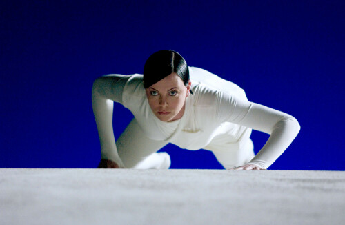 Charlize Theron by Jasin Boland for 'Aeon Flux' Promotional Stills 2005

Aeon Flux

In a 25th-century totalitarian fortress city, Charlize Theron, as the solemn rebel ninja babe Aeon Flux, does slow-motion flips and twirls that show off her luxurious elongated physique to stunning effect. With slick, flattened black hair that makes it look as if her stylist was going for that Louise Brooks-meets-Hitler mystique, Theron is an arresting image, but, like everything else in Aeon Flux, she?s stranded in a trashy and derivative glum zone of fashion-runway fascism. Ordered by her underground leader (Frances McDormand, looking like she?s holding back a chuckle) to assassinate the head of the city (Marton Csokas), Aeon discovers that he?s not the baddie he seems — and, in fact, that everyone, including her, is not quite what they seem.

Based on the animated MTV series, Aeon Flux has several entertaining action sequences, like one in which Theron, crawling like a spider, dodges metal blades that pop out of the grass. But the movie, while not as cheesy-bad as, say, Daredevil, generates more motion than imagination. Theron plays Aeon as a reluctant cipher who yearns to get back to a real existence. By the end, you?ll know the feeling.