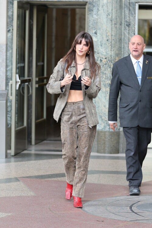 Emily Ratajkowski flashes her toned abs in a crop top paired with scarlet animal-print boots as she steps out in NYC - April 11, 2023

Emily Ratajkowski flashes her toned abs in a crop top paired with scarlet animal-print boots as she steps out in NYC - amid new Harry Styles romance

Emily Ratajkowski commanded attention on Tuesday as she stepped out in an eye-catching look in New York City amid her new romance with Harry Styles.

The 31-year-old supermodel — who was spotted with her son Sly on Monday — strutted her stuff in a plunging black crop top that exposed her enviable abs.

The mother-of-one wore a textured brown co-ord consisting of a jacket and matching trousers.

She teamed the fashion-forward look with a pair of bright, red, square-toed boots with a snake print design.

The High/Low With Emrata podcast host elevated the ensemble with a pair of lightly-tinted, narrow sunglasses with a black frame.

Emily, who is is a New York Times Bestselling author thanks to her book My Body, wore her chocolate-brown locks loose.

Her lustrous strands fell over her chest as she rocked them in an imperfect center part and face-framing bangs.

She donned a gold and black chain link necklace, along with chunky, medium-sized gold hoop earrings.

The runway regular slung a small, dark handbag over her shoulder and showed off a full face of makeup.

Last month the doting mom took to Instagram to share outtakes from the little boy's Paw Patrol themed birthday bash.

Emily recently broke her silence on the passionate, public kiss she shared with pop star Harry Styles in Tokyo.

While speaking with the Los Angeles Times, the star commented on the viral kiss, stating, 'There’s a million insane, inaccurate things about my relationships [that are said].'

'I’m definitely still not thinking about guys,' she continued, adding, 'Although, yeah. You know, sometimes things just happen.'

Shortly after the kiss, a source had told The Sun, 'They aren’t hiding anything,' and that the two 'are enjoying getting to know each other.'

'Getting filmed kissing in Tokyo and then that footage being shared with the world wasn’t what either of them expected — but they aren’t hiding anything,' the person reiterated.

In March, Emily hinted at a possible romance with the British-born singer, although she did not disclose his name, when appearing on the podcast Going Mental With Eileen Kelly.

'I just started dating someone that I kinda like, so that feels different,' she dished. 'He's kinda great.'

In the LA Times interview, the star also revealed that she stopped going to networking parties, as they were filled with 'disgusting' middle-aged men.

Since her split from Sebastian last summer, Ratajkowski has been linked to celebrities such as Pete Davidson, comedian Eric Andre, and most recently Harry Styles.

Emily talked about how news of her divorce got out while on an episode of the podcast Forbidden Fruits with Julia Fox and Niki Takesh : 'I went to a party where it was just, like, every famous person in the world and I was, like, not wearing my ring, and it, like, spread by the end of the night and I had so much fun.

However, she acknowledged the difficulties of being in the public eye when it comes to her romantic life.

'I went to a basketball game with my girlfriend, who is friends with a guy who had an extra seat, and when I came back from halftime, we switched, I sat next to him, and there were, like, a million pictures, like, 'EmRata seen on a date with so and so,' she recalled, adding, 'Can I get a fucking break?'