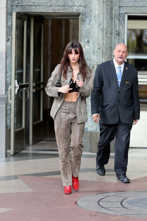 Emily Ratajkowski flashes her toned abs in a crop top paired with scarlet animal-print boots as she steps out in NYC - April 11, 2023

Emily Ratajkowski flashes her toned abs in a crop top paired with scarlet animal-print boots as she steps out in NYC - amid new Harry Styles romance

Emily Ratajkowski commanded attention on Tuesday as she stepped out in an eye-catching look in New York City amid her new romance with Harry Styles.

The 31-year-old supermodel — who was spotted with her son Sly on Monday — strutted her stuff in a plunging black crop top that exposed her enviable abs.

The mother-of-one wore a textured brown co-ord consisting of a jacket and matching trousers.

She teamed the fashion-forward look with a pair of bright, red, square-toed boots with a snake print design.

The High/Low With Emrata podcast host elevated the ensemble with a pair of lightly-tinted, narrow sunglasses with a black frame.

Emily, who is is a New York Times Bestselling author thanks to her book My Body, wore her chocolate-brown locks loose.

Her lustrous strands fell over her chest as she rocked them in an imperfect center part and face-framing bangs.

She donned a gold and black chain link necklace, along with chunky, medium-sized gold hoop earrings.

The runway regular slung a small, dark handbag over her shoulder and showed off a full face of makeup.

Last month the doting mom took to Instagram to share outtakes from the little boy's Paw Patrol themed birthday bash.

Emily recently broke her silence on the passionate, public kiss she shared with pop star Harry Styles in Tokyo.

While speaking with the Los Angeles Times, the star commented on the viral kiss, stating, 'There’s a million insane, inaccurate things about my relationships [that are said].'

'I’m definitely still not thinking about guys,' she continued, adding, 'Although, yeah. You know, sometimes things just happen.'

Shortly after the kiss, a source had told The Sun, 'They aren’t hiding anything,' and that the two 'are enjoying getting to know each other.'

'Getting filmed kissing in Tokyo and then that footage being shared with the world wasn’t what either of them expected — but they aren’t hiding anything,' the person reiterated.

In March, Emily hinted at a possible romance with the British-born singer, although she did not disclose his name, when appearing on the podcast Going Mental With Eileen Kelly.

'I just started dating someone that I kinda like, so that feels different,' she dished. 'He's kinda great.'

In the LA Times interview, the star also revealed that she stopped going to networking parties, as they were filled with 'disgusting' middle-aged men.

Since her split from Sebastian last summer, Ratajkowski has been linked to celebrities such as Pete Davidson, comedian Eric Andre, and most recently Harry Styles.

Emily talked about how news of her divorce got out while on an episode of the podcast Forbidden Fruits with Julia Fox and Niki Takesh : 'I went to a party where it was just, like, every famous person in the world and I was, like, not wearing my ring, and it, like, spread by the end of the night and I had so much fun.

However, she acknowledged the difficulties of being in the public eye when it comes to her romantic life.

'I went to a basketball game with my girlfriend, who is friends with a guy who had an extra seat, and when I came back from halftime, we switched, I sat next to him, and there were, like, a million pictures, like, 'EmRata seen on a date with so and so,' she recalled, adding, 'Can I get a fucking break?'