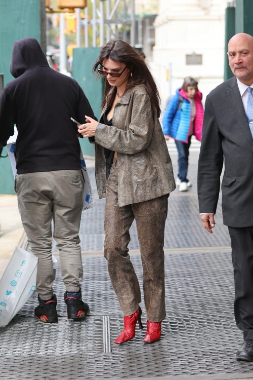 Emily Ratajkowski flashes her toned abs in a crop top paired with scarlet animal-print boots as she steps out in NYC - April 11, 2023

Emily Ratajkowski flashes her toned abs in a crop top paired with scarlet animal-print boots as she steps out in NYC - amid new Harry Styles romance

Emily Ratajkowski commanded attention on Tuesday as she stepped out in an eye-catching look in New York City amid her new romance with Harry Styles.

The 31-year-old supermodel — who was spotted with her son Sly on Monday — strutted her stuff in a plunging black crop top that exposed her enviable abs.

The mother-of-one wore a textured brown co-ord consisting of a jacket and matching trousers.

She teamed the fashion-forward look with a pair of bright, red, square-toed boots with a snake print design.

The High/Low With Emrata podcast host elevated the ensemble with a pair of lightly-tinted, narrow sunglasses with a black frame.

Emily, who is is a New York Times Bestselling author thanks to her book My Body, wore her chocolate-brown locks loose.

Her lustrous strands fell over her chest as she rocked them in an imperfect center part and face-framing bangs.

She donned a gold and black chain link necklace, along with chunky, medium-sized gold hoop earrings.

The runway regular slung a small, dark handbag over her shoulder and showed off a full face of makeup.

Last month the doting mom took to Instagram to share outtakes from the little boy's Paw Patrol themed birthday bash.

Emily recently broke her silence on the passionate, public kiss she shared with pop star Harry Styles in Tokyo.

While speaking with the Los Angeles Times, the star commented on the viral kiss, stating, 'There’s a million insane, inaccurate things about my relationships [that are said].'

'I’m definitely still not thinking about guys,' she continued, adding, 'Although, yeah. You know, sometimes things just happen.'

Shortly after the kiss, a source had told The Sun, 'They aren’t hiding anything,' and that the two 'are enjoying getting to know each other.'

'Getting filmed kissing in Tokyo and then that footage being shared with the world wasn’t what either of them expected — but they aren’t hiding anything,' the person reiterated.

In March, Emily hinted at a possible romance with the British-born singer, although she did not disclose his name, when appearing on the podcast Going Mental With Eileen Kelly.

'I just started dating someone that I kinda like, so that feels different,' she dished. 'He's kinda great.'

In the LA Times interview, the star also revealed that she stopped going to networking parties, as they were filled with 'disgusting' middle-aged men.

Since her split from Sebastian last summer, Ratajkowski has been linked to celebrities such as Pete Davidson, comedian Eric Andre, and most recently Harry Styles.

Emily talked about how news of her divorce got out while on an episode of the podcast Forbidden Fruits with Julia Fox and Niki Takesh : 'I went to a party where it was just, like, every famous person in the world and I was, like, not wearing my ring, and it, like, spread by the end of the night and I had so much fun.

However, she acknowledged the difficulties of being in the public eye when it comes to her romantic life.

'I went to a basketball game with my girlfriend, who is friends with a guy who had an extra seat, and when I came back from halftime, we switched, I sat next to him, and there were, like, a million pictures, like, 'EmRata seen on a date with so and so,' she recalled, adding, 'Can I get a fucking break?'