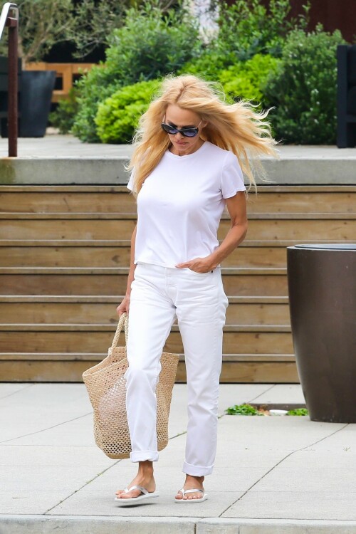 Pamela Anderson - April 10 2023 - Candids

Pamela Anderson Stuns In Head To Toe White 2 Months After Documentary Debut: Photos

After wowing in a slip dress in St. Barts last week, Pamela Anderson stepped out to run errands in an all-white ensemble on Apr. 10, two months after her documentary hit Netflix.

Love, Pamela author Pamela Anderson, 55, has been serving nonstop stunning looks as of late, with her most recent being while running errands in Malibu on Monday. While the blonde beauty was out shopping in the beach city, she rocked an all-white ensemble that included a white t-shirt and white jeans. Pamela rolled up the hem of her pants and paired the look with flip-flops, black sunglasses, and a straw beach tote bag.

Later, the 55-year-old was spotted in the same outfit, however, she bundled up with a white long-sleeve knitted turtleneck for the chilly afternoon. Pamela also swapped her casual sandals for chic open-toe nude high heels on the way back to her vehicle. The Pamela: A Love Story star wore her famous platinum blonde tresses straight down and parted them just slightly off-center.

Pamela’s day of shopping in Malibu comes just one week after she was spotted on a tropical vacation in St. Barts with her son, Dylan Jagger Lee, 25, and a mystery man. During her vacation, she wowed in an ivory slip dress, as she was pictured holding her black high heels in her hand. She paired the look with oversized black sunglasses and a different straw beach tote bag on the island. That week, Pamela also took to Instagram to share a carousel of photos of her walking on the beach. “An ocean energy – explores and surprises…,” she captioned the post.

The mother-of-two’s outing in Malibu also comes just over two months after the release of her Netflix documentary, Pamela: A Love Story. The doc takes a closer look at the starlet as she revealed never-before-seen footage and stories from her personal life. Her film also examined her relationship with her ex-husband, Tommy Lee, 60, who she divorced in 1998. The couple welcomed two sons: Dylan and Brandon Thomas Lee, 26. She even admitted to her eldest son that she has only ever loved his father. “I was just thinking about it upstairs. I was thinking, you know… It’s probably gonna get me a lot of s*** for saying this, but I really loved your dad, like, for all the right reasons and I don’t think I’ve ever loved anybody else,” she gushed during the film.

The Baywatch alum announced her split from her fourth husband, Dan Hayhurst, in Jan. 2022. The pair got married in 2020, however, she recently called their marriage a “disaster” during a Jan. 30 interview with Vanity Fair. She said that the COVID-19 pandemic led her to “romanticize everything. Everyone was looking good — all the contractors that were here.” Pamela added, “It ended up being a disaster.” Prior to Dan, she was married to Rick Salomon from 2007 until 2008 and again from 2014 until 2015. Even earlier, she wed Kid Rock from early 2006 until late 2006. At the moment, Pamela is living her best single life.