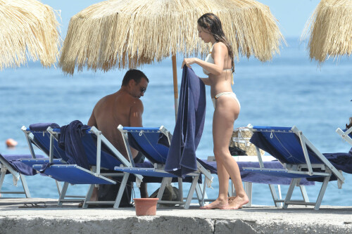 Kelly Brook - White Bikini Candids - Ischia, Italy - July 14, 2011

Ciao bella! Kelly Brook looks just creamy in a pale bikini as she takes a cooling dip on holiday in the Bay Of Naples

She's been having fun in the Italian sun after hitting the Ischia Film Festival to boost her profile as an actress - and now Kelly Brook has revealed the figure that her fans know and love on the beach.

The curvy 31-year-old stripped down to a cream bikini at her hotel to top up her tan with a friend and have a refreshing swim in the Tyrrhenian Sea.

The stunning model is having a few days off now the festival has finished and today decided to relax by the pool at her hotel on the island of Ischia after a day trip across the bay to Naples yesterday.

Kelly is staying at the L'Albergo Della Regina Isabella on the island in the Bay Of Naples and chose to have a dip in one of the hotel's three pools.

She also larked about with a friend and took a picture of the two of them together

Built on ancient Greek-Roman ruins on the seashore, it was built in the Dolce Vita era of the 1950s.

Kelly will also be looking forward to the live music in the cocktail bar every evening.

However, Kelly's boyfriend Thom won't be joining her.

Her spokesman told Mail Online: 'She's gone out with her U.S. agent but will back at the weekend and no, Thom isn't joining her as it's a quick trip.'

Yesterday, Kelly's smile was almost as sunny as the weather yesterday as the star enjoyed a day trip to Naples across the water.

She turned tourist as she strolled the streets of old Napoli before taking to the waves on a boat trip.

The beaming star was wearing a gorgeous 1950s-style sundress from the Jasper Conran Spring/Summer 2011 collection with a cute seaside print and had teamed it with cute lemon yellow Superga plimsolls with white soles and a chic Louis Vuitton handbag.

Kelly flew out earlier this week to the island of Ischia, which is in the Bay Of Naples, for the annual film festival.

However, there's been no sign of her hunky boyfriend Thom Evans as yet.

Kelly is certainly enjoying herself regardless.

She wrote on her Twitter in the early hours of this morning: 'Just took a boat ride home under a full moon with beautiful people. Viva Italia'.

Fans of Kelly - and probably a lot of those Italian men - will be hoping that Kelly pays a visit to the beach while she's there.

The model has teamed up with New Look to launch a swimwear range which has proved popular with stars of The Only Way Is Essex.

Kelly could use her holiday as a chance to model her own pieces while topping up her tan at the same time.

DailyMail