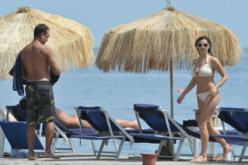 Kelly Brook - White Bikini Candids - Ischia, Italy - July 14, 2011

Ciao bella! Kelly Brook looks just creamy in a pale bikini as she takes a cooling dip on holiday in the Bay Of Naples

She's been having fun in the Italian sun after hitting the Ischia Film Festival to boost her profile as an actress - and now Kelly Brook has revealed the figure that her fans know and love on the beach.

The curvy 31-year-old stripped down to a cream bikini at her hotel to top up her tan with a friend and have a refreshing swim in the Tyrrhenian Sea.

The stunning model is having a few days off now the festival has finished and today decided to relax by the pool at her hotel on the island of Ischia after a day trip across the bay to Naples yesterday.

Kelly is staying at the L'Albergo Della Regina Isabella on the island in the Bay Of Naples and chose to have a dip in one of the hotel's three pools.

She also larked about with a friend and took a picture of the two of them together

Built on ancient Greek-Roman ruins on the seashore, it was built in the Dolce Vita era of the 1950s.

Kelly will also be looking forward to the live music in the cocktail bar every evening.

However, Kelly's boyfriend Thom won't be joining her.

Her spokesman told Mail Online: 'She's gone out with her U.S. agent but will back at the weekend and no, Thom isn't joining her as it's a quick trip.'

Yesterday, Kelly's smile was almost as sunny as the weather yesterday as the star enjoyed a day trip to Naples across the water.

She turned tourist as she strolled the streets of old Napoli before taking to the waves on a boat trip.

The beaming star was wearing a gorgeous 1950s-style sundress from the Jasper Conran Spring/Summer 2011 collection with a cute seaside print and had teamed it with cute lemon yellow Superga plimsolls with white soles and a chic Louis Vuitton handbag.

Kelly flew out earlier this week to the island of Ischia, which is in the Bay Of Naples, for the annual film festival.

However, there's been no sign of her hunky boyfriend Thom Evans as yet.

Kelly is certainly enjoying herself regardless.

She wrote on her Twitter in the early hours of this morning: 'Just took a boat ride home under a full moon with beautiful people. Viva Italia'.

Fans of Kelly - and probably a lot of those Italian men - will be hoping that Kelly pays a visit to the beach while she's there.

The model has teamed up with New Look to launch a swimwear range which has proved popular with stars of The Only Way Is Essex.

Kelly could use her holiday as a chance to model her own pieces while topping up her tan at the same time.

DailyMail