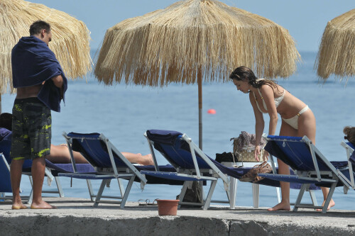 Kelly Brook - White Bikini Candids - Ischia, Italy - July 14, 2011

Ciao bella! Kelly Brook looks just creamy in a pale bikini as she takes a cooling dip on holiday in the Bay Of Naples

She's been having fun in the Italian sun after hitting the Ischia Film Festival to boost her profile as an actress - and now Kelly Brook has revealed the figure that her fans know and love on the beach.

The curvy 31-year-old stripped down to a cream bikini at her hotel to top up her tan with a friend and have a refreshing swim in the Tyrrhenian Sea.

The stunning model is having a few days off now the festival has finished and today decided to relax by the pool at her hotel on the island of Ischia after a day trip across the bay to Naples yesterday.

Kelly is staying at the L'Albergo Della Regina Isabella on the island in the Bay Of Naples and chose to have a dip in one of the hotel's three pools.

She also larked about with a friend and took a picture of the two of them together

Built on ancient Greek-Roman ruins on the seashore, it was built in the Dolce Vita era of the 1950s.

Kelly will also be looking forward to the live music in the cocktail bar every evening.

However, Kelly's boyfriend Thom won't be joining her.

Her spokesman told Mail Online: 'She's gone out with her U.S. agent but will back at the weekend and no, Thom isn't joining her as it's a quick trip.'

Yesterday, Kelly's smile was almost as sunny as the weather yesterday as the star enjoyed a day trip to Naples across the water.

She turned tourist as she strolled the streets of old Napoli before taking to the waves on a boat trip.

The beaming star was wearing a gorgeous 1950s-style sundress from the Jasper Conran Spring/Summer 2011 collection with a cute seaside print and had teamed it with cute lemon yellow Superga plimsolls with white soles and a chic Louis Vuitton handbag.

Kelly flew out earlier this week to the island of Ischia, which is in the Bay Of Naples, for the annual film festival.

However, there's been no sign of her hunky boyfriend Thom Evans as yet.

Kelly is certainly enjoying herself regardless.

She wrote on her Twitter in the early hours of this morning: 'Just took a boat ride home under a full moon with beautiful people. Viva Italia'.

Fans of Kelly - and probably a lot of those Italian men - will be hoping that Kelly pays a visit to the beach while she's there.

The model has teamed up with New Look to launch a swimwear range which has proved popular with stars of The Only Way Is Essex.

Kelly could use her holiday as a chance to model her own pieces while topping up her tan at the same time.

DailyMail