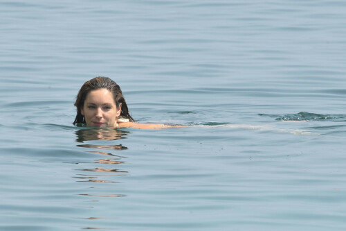 Kelly Brook - White Bikini Candids - Ischia, Italy - July 14, 2011

Ciao bella! Kelly Brook looks just creamy in a pale bikini as she takes a cooling dip on holiday in the Bay Of Naples

She's been having fun in the Italian sun after hitting the Ischia Film Festival to boost her profile as an actress - and now Kelly Brook has revealed the figure that her fans know and love on the beach.

The curvy 31-year-old stripped down to a cream bikini at her hotel to top up her tan with a friend and have a refreshing swim in the Tyrrhenian Sea.

The stunning model is having a few days off now the festival has finished and today decided to relax by the pool at her hotel on the island of Ischia after a day trip across the bay to Naples yesterday.

Kelly is staying at the L'Albergo Della Regina Isabella on the island in the Bay Of Naples and chose to have a dip in one of the hotel's three pools.

She also larked about with a friend and took a picture of the two of them together

Built on ancient Greek-Roman ruins on the seashore, it was built in the Dolce Vita era of the 1950s.

Kelly will also be looking forward to the live music in the cocktail bar every evening.

However, Kelly's boyfriend Thom won't be joining her.

Her spokesman told Mail Online: 'She's gone out with her U.S. agent but will back at the weekend and no, Thom isn't joining her as it's a quick trip.'

Yesterday, Kelly's smile was almost as sunny as the weather yesterday as the star enjoyed a day trip to Naples across the water.

She turned tourist as she strolled the streets of old Napoli before taking to the waves on a boat trip.

The beaming star was wearing a gorgeous 1950s-style sundress from the Jasper Conran Spring/Summer 2011 collection with a cute seaside print and had teamed it with cute lemon yellow Superga plimsolls with white soles and a chic Louis Vuitton handbag.

Kelly flew out earlier this week to the island of Ischia, which is in the Bay Of Naples, for the annual film festival.

However, there's been no sign of her hunky boyfriend Thom Evans as yet.

Kelly is certainly enjoying herself regardless.

She wrote on her Twitter in the early hours of this morning: 'Just took a boat ride home under a full moon with beautiful people. Viva Italia'.

Fans of Kelly - and probably a lot of those Italian men - will be hoping that Kelly pays a visit to the beach while she's there.

The model has teamed up with New Look to launch a swimwear range which has proved popular with stars of The Only Way Is Essex.

Kelly could use her holiday as a chance to model her own pieces while topping up her tan at the same time.

DailyMail