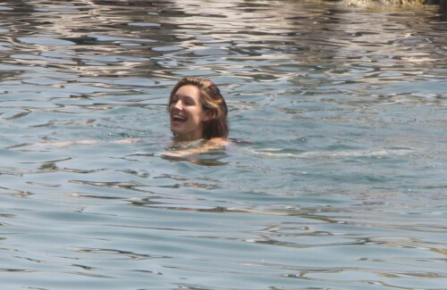 Kelly Brook - White Bikini Candids - Ischia, Italy - July 14, 2011

Ciao bella! Kelly Brook looks just creamy in a pale bikini as she takes a cooling dip on holiday in the Bay Of Naples

She's been having fun in the Italian sun after hitting the Ischia Film Festival to boost her profile as an actress - and now Kelly Brook has revealed the figure that her fans know and love on the beach.

The curvy 31-year-old stripped down to a cream bikini at her hotel to top up her tan with a friend and have a refreshing swim in the Tyrrhenian Sea.

The stunning model is having a few days off now the festival has finished and today decided to relax by the pool at her hotel on the island of Ischia after a day trip across the bay to Naples yesterday.

Kelly is staying at the L'Albergo Della Regina Isabella on the island in the Bay Of Naples and chose to have a dip in one of the hotel's three pools.

She also larked about with a friend and took a picture of the two of them together

Built on ancient Greek-Roman ruins on the seashore, it was built in the Dolce Vita era of the 1950s.

Kelly will also be looking forward to the live music in the cocktail bar every evening.

However, Kelly's boyfriend Thom won't be joining her.

Her spokesman told Mail Online: 'She's gone out with her U.S. agent but will back at the weekend and no, Thom isn't joining her as it's a quick trip.'

Yesterday, Kelly's smile was almost as sunny as the weather yesterday as the star enjoyed a day trip to Naples across the water.

She turned tourist as she strolled the streets of old Napoli before taking to the waves on a boat trip.

The beaming star was wearing a gorgeous 1950s-style sundress from the Jasper Conran Spring/Summer 2011 collection with a cute seaside print and had teamed it with cute lemon yellow Superga plimsolls with white soles and a chic Louis Vuitton handbag.

Kelly flew out earlier this week to the island of Ischia, which is in the Bay Of Naples, for the annual film festival.

However, there's been no sign of her hunky boyfriend Thom Evans as yet.

Kelly is certainly enjoying herself regardless.

She wrote on her Twitter in the early hours of this morning: 'Just took a boat ride home under a full moon with beautiful people. Viva Italia'.

Fans of Kelly - and probably a lot of those Italian men - will be hoping that Kelly pays a visit to the beach while she's there.

The model has teamed up with New Look to launch a swimwear range which has proved popular with stars of The Only Way Is Essex.

Kelly could use her holiday as a chance to model her own pieces while topping up her tan at the same time.

DailyMail