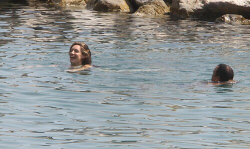 Kelly Brook - White Bikini Candids - Ischia, Italy - July 14, 2011

Ciao bella! Kelly Brook looks just creamy in a pale bikini as she takes a cooling dip on holiday in the Bay Of Naples

She's been having fun in the Italian sun after hitting the Ischia Film Festival to boost her profile as an actress - and now Kelly Brook has revealed the figure that her fans know and love on the beach.

The curvy 31-year-old stripped down to a cream bikini at her hotel to top up her tan with a friend and have a refreshing swim in the Tyrrhenian Sea.

The stunning model is having a few days off now the festival has finished and today decided to relax by the pool at her hotel on the island of Ischia after a day trip across the bay to Naples yesterday.

Kelly is staying at the L'Albergo Della Regina Isabella on the island in the Bay Of Naples and chose to have a dip in one of the hotel's three pools.

She also larked about with a friend and took a picture of the two of them together

Built on ancient Greek-Roman ruins on the seashore, it was built in the Dolce Vita era of the 1950s.

Kelly will also be looking forward to the live music in the cocktail bar every evening.

However, Kelly's boyfriend Thom won't be joining her.

Her spokesman told Mail Online: 'She's gone out with her U.S. agent but will back at the weekend and no, Thom isn't joining her as it's a quick trip.'

Yesterday, Kelly's smile was almost as sunny as the weather yesterday as the star enjoyed a day trip to Naples across the water.

She turned tourist as she strolled the streets of old Napoli before taking to the waves on a boat trip.

The beaming star was wearing a gorgeous 1950s-style sundress from the Jasper Conran Spring/Summer 2011 collection with a cute seaside print and had teamed it with cute lemon yellow Superga plimsolls with white soles and a chic Louis Vuitton handbag.

Kelly flew out earlier this week to the island of Ischia, which is in the Bay Of Naples, for the annual film festival.

However, there's been no sign of her hunky boyfriend Thom Evans as yet.

Kelly is certainly enjoying herself regardless.

She wrote on her Twitter in the early hours of this morning: 'Just took a boat ride home under a full moon with beautiful people. Viva Italia'.

Fans of Kelly - and probably a lot of those Italian men - will be hoping that Kelly pays a visit to the beach while she's there.

The model has teamed up with New Look to launch a swimwear range which has proved popular with stars of The Only Way Is Essex.

Kelly could use her holiday as a chance to model her own pieces while topping up her tan at the same time.

DailyMail