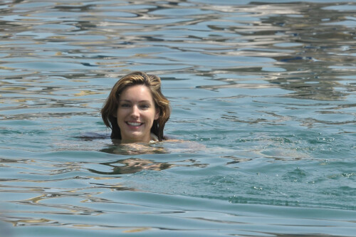 Kelly Brook - White Bikini Candids - Ischia, Italy - July 14, 2011

Ciao bella! Kelly Brook looks just creamy in a pale bikini as she takes a cooling dip on holiday in the Bay Of Naples

She's been having fun in the Italian sun after hitting the Ischia Film Festival to boost her profile as an actress - and now Kelly Brook has revealed the figure that her fans know and love on the beach.

The curvy 31-year-old stripped down to a cream bikini at her hotel to top up her tan with a friend and have a refreshing swim in the Tyrrhenian Sea.

The stunning model is having a few days off now the festival has finished and today decided to relax by the pool at her hotel on the island of Ischia after a day trip across the bay to Naples yesterday.

Kelly is staying at the L'Albergo Della Regina Isabella on the island in the Bay Of Naples and chose to have a dip in one of the hotel's three pools.

She also larked about with a friend and took a picture of the two of them together

Built on ancient Greek-Roman ruins on the seashore, it was built in the Dolce Vita era of the 1950s.

Kelly will also be looking forward to the live music in the cocktail bar every evening.

However, Kelly's boyfriend Thom won't be joining her.

Her spokesman told Mail Online: 'She's gone out with her U.S. agent but will back at the weekend and no, Thom isn't joining her as it's a quick trip.'

Yesterday, Kelly's smile was almost as sunny as the weather yesterday as the star enjoyed a day trip to Naples across the water.

She turned tourist as she strolled the streets of old Napoli before taking to the waves on a boat trip.

The beaming star was wearing a gorgeous 1950s-style sundress from the Jasper Conran Spring/Summer 2011 collection with a cute seaside print and had teamed it with cute lemon yellow Superga plimsolls with white soles and a chic Louis Vuitton handbag.

Kelly flew out earlier this week to the island of Ischia, which is in the Bay Of Naples, for the annual film festival.

However, there's been no sign of her hunky boyfriend Thom Evans as yet.

Kelly is certainly enjoying herself regardless.

She wrote on her Twitter in the early hours of this morning: 'Just took a boat ride home under a full moon with beautiful people. Viva Italia'.

Fans of Kelly - and probably a lot of those Italian men - will be hoping that Kelly pays a visit to the beach while she's there.

The model has teamed up with New Look to launch a swimwear range which has proved popular with stars of The Only Way Is Essex.

Kelly could use her holiday as a chance to model her own pieces while topping up her tan at the same time.

DailyMail