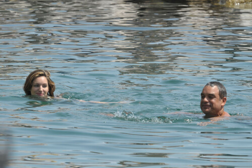 Kelly Brook - White Bikini Candids - Ischia, Italy - July 14, 2011

Ciao bella! Kelly Brook looks just creamy in a pale bikini as she takes a cooling dip on holiday in the Bay Of Naples

She's been having fun in the Italian sun after hitting the Ischia Film Festival to boost her profile as an actress - and now Kelly Brook has revealed the figure that her fans know and love on the beach.

The curvy 31-year-old stripped down to a cream bikini at her hotel to top up her tan with a friend and have a refreshing swim in the Tyrrhenian Sea.

The stunning model is having a few days off now the festival has finished and today decided to relax by the pool at her hotel on the island of Ischia after a day trip across the bay to Naples yesterday.

Kelly is staying at the L'Albergo Della Regina Isabella on the island in the Bay Of Naples and chose to have a dip in one of the hotel's three pools.

She also larked about with a friend and took a picture of the two of them together

Built on ancient Greek-Roman ruins on the seashore, it was built in the Dolce Vita era of the 1950s.

Kelly will also be looking forward to the live music in the cocktail bar every evening.

However, Kelly's boyfriend Thom won't be joining her.

Her spokesman told Mail Online: 'She's gone out with her U.S. agent but will back at the weekend and no, Thom isn't joining her as it's a quick trip.'

Yesterday, Kelly's smile was almost as sunny as the weather yesterday as the star enjoyed a day trip to Naples across the water.

She turned tourist as she strolled the streets of old Napoli before taking to the waves on a boat trip.

The beaming star was wearing a gorgeous 1950s-style sundress from the Jasper Conran Spring/Summer 2011 collection with a cute seaside print and had teamed it with cute lemon yellow Superga plimsolls with white soles and a chic Louis Vuitton handbag.

Kelly flew out earlier this week to the island of Ischia, which is in the Bay Of Naples, for the annual film festival.

However, there's been no sign of her hunky boyfriend Thom Evans as yet.

Kelly is certainly enjoying herself regardless.

She wrote on her Twitter in the early hours of this morning: 'Just took a boat ride home under a full moon with beautiful people. Viva Italia'.

Fans of Kelly - and probably a lot of those Italian men - will be hoping that Kelly pays a visit to the beach while she's there.

The model has teamed up with New Look to launch a swimwear range which has proved popular with stars of The Only Way Is Essex.

Kelly could use her holiday as a chance to model her own pieces while topping up her tan at the same time.

DailyMail