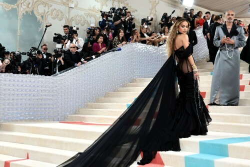 Rita Ora Makes a Case for Sheer on Met Gala Red Carpet 2023 in Prabal Gurung Dress & Strappy Sandals With Taika Waititi

Rita Ora arrived at the 2023 Met Gala in New York wearing an all-black ensemble. The singer posed on the carpet with her husband, director Taika Waititi.

Ora donned a daring outfit that featured detailed draping, striking cutouts and well-defined boning from Prabal Gurung.

The Nepalese-American fashion designer has been a fixture at the Met Gala since 2010. His designs have graced the red carpet, showcasing his signature style that often combines traditional Nepalese influences with modern, edgy elements. He has dressed a range of celebrities, from Sarah Jessica Parker to Zendaya over the years.

Regarding her footwear choice, Ora strapped on a pair of strappy sandals with a generous platform. These strappy platform sandals feature a chic ankle buckle closure that provides a secure fit. The almond toe design adds a touch of elegance, while the 6-inch heel elongates the legs and creates a flattering silhouette.

Ora’s fashion style is a mix of edgy and glamorous, often pushing boundaries with bold statement pieces. She is known for wearing daring outfits that showcase her confident and daring personality. Rita has also been a standout at the Met Gala, consistently impressing with her unique and avant-garde choices. From her bold silver feathered gown in 2016 to her Prada moment in 2021, she always manages to turn heads on the red carpet.

The Met Gala raises funds for the Metropolitan Museum of Art in New York City and celebrates the Costume Institute’s annual exhibits. This year’s theme, “Karl Lagerfeld: A Line of Beauty,” celebrates the life and career of designer Karl Lagerfeld. The 2023 event is notably co-chaired by Dua Lipa, Roger Federer, Michaela Coel, Penelope Cruz and Vogue editor-in-chief Anna Wintour.

Rita Ora attends The 2023 Met Gala Celebrating "Karl Lagerfeld: A Line Of Beauty" at The Metropolitan Museum of Art on May 01, 2023 in New York City.

Met Gala 2023: Rita Ora sizzles in a black sheer gown as she joins dapper husband Taika Waititi on the star-studded red carpet.

Rita Ora brought the goth glamour to the Met Gala 2023 red carpet with a sheer corseted gown by Prabal Gurung.

#RitaOra #2023MetGala