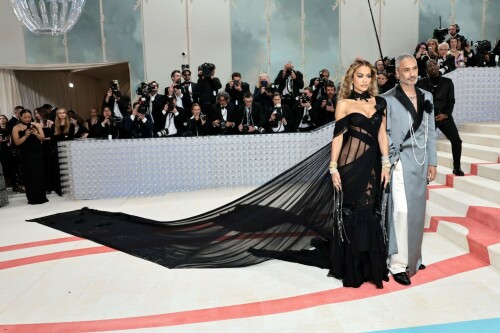 Rita Ora Makes a Case for Sheer on Met Gala Red Carpet 2023 in Prabal Gurung Dress & Strappy Sandals With Taika Waititi

Rita Ora arrived at the 2023 Met Gala in New York wearing an all-black ensemble. The singer posed on the carpet with her husband, director Taika Waititi.

Ora donned a daring outfit that featured detailed draping, striking cutouts and well-defined boning from Prabal Gurung.

The Nepalese-American fashion designer has been a fixture at the Met Gala since 2010. His designs have graced the red carpet, showcasing his signature style that often combines traditional Nepalese influences with modern, edgy elements. He has dressed a range of celebrities, from Sarah Jessica Parker to Zendaya over the years.

Regarding her footwear choice, Ora strapped on a pair of strappy sandals with a generous platform. These strappy platform sandals feature a chic ankle buckle closure that provides a secure fit. The almond toe design adds a touch of elegance, while the 6-inch heel elongates the legs and creates a flattering silhouette.

Ora’s fashion style is a mix of edgy and glamorous, often pushing boundaries with bold statement pieces. She is known for wearing daring outfits that showcase her confident and daring personality. Rita has also been a standout at the Met Gala, consistently impressing with her unique and avant-garde choices. From her bold silver feathered gown in 2016 to her Prada moment in 2021, she always manages to turn heads on the red carpet.

The Met Gala raises funds for the Metropolitan Museum of Art in New York City and celebrates the Costume Institute’s annual exhibits. This year’s theme, “Karl Lagerfeld: A Line of Beauty,” celebrates the life and career of designer Karl Lagerfeld. The 2023 event is notably co-chaired by Dua Lipa, Roger Federer, Michaela Coel, Penelope Cruz and Vogue editor-in-chief Anna Wintour.

Rita Ora attends The 2023 Met Gala Celebrating "Karl Lagerfeld: A Line Of Beauty" at The Metropolitan Museum of Art on May 01, 2023 in New York City.

Met Gala 2023: Rita Ora sizzles in a black sheer gown as she joins dapper husband Taika Waititi on the star-studded red carpet.

Rita Ora brought the goth glamour to the Met Gala 2023 red carpet with a sheer corseted gown by Prabal Gurung.

#RitaOra #2023MetGala