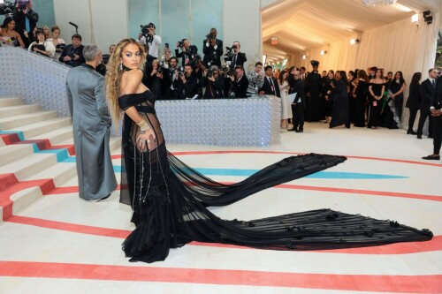 Rita Ora Makes a Case for Sheer on Met Gala Red Carpet 2023 in Prabal Gurung Dress & Strappy Sandals With Taika Waititi

Rita Ora arrived at the 2023 Met Gala in New York wearing an all-black ensemble. The singer posed on the carpet with her husband, director Taika Waititi.

Ora donned a daring outfit that featured detailed draping, striking cutouts and well-defined boning from Prabal Gurung.

The Nepalese-American fashion designer has been a fixture at the Met Gala since 2010. His designs have graced the red carpet, showcasing his signature style that often combines traditional Nepalese influences with modern, edgy elements. He has dressed a range of celebrities, from Sarah Jessica Parker to Zendaya over the years.

Regarding her footwear choice, Ora strapped on a pair of strappy sandals with a generous platform. These strappy platform sandals feature a chic ankle buckle closure that provides a secure fit. The almond toe design adds a touch of elegance, while the 6-inch heel elongates the legs and creates a flattering silhouette.

Ora’s fashion style is a mix of edgy and glamorous, often pushing boundaries with bold statement pieces. She is known for wearing daring outfits that showcase her confident and daring personality. Rita has also been a standout at the Met Gala, consistently impressing with her unique and avant-garde choices. From her bold silver feathered gown in 2016 to her Prada moment in 2021, she always manages to turn heads on the red carpet.

The Met Gala raises funds for the Metropolitan Museum of Art in New York City and celebrates the Costume Institute’s annual exhibits. This year’s theme, “Karl Lagerfeld: A Line of Beauty,” celebrates the life and career of designer Karl Lagerfeld. The 2023 event is notably co-chaired by Dua Lipa, Roger Federer, Michaela Coel, Penelope Cruz and Vogue editor-in-chief Anna Wintour.

Rita Ora attends The 2023 Met Gala Celebrating "Karl Lagerfeld: A Line Of Beauty" at The Metropolitan Museum of Art on May 01, 2023 in New York City.

Met Gala 2023: Rita Ora sizzles in a black sheer gown as she joins dapper husband Taika Waititi on the star-studded red carpet.

Rita Ora brought the goth glamour to the Met Gala 2023 red carpet with a sheer corseted gown by Prabal Gurung.

#RitaOra #2023MetGala