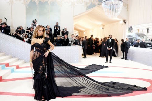 Met Gala 2023: Rita Ora Is Serving Fashion Witch at The Met Gala

May shmay! It's spooky season for Rita.

Fifty Shades of Grey actor Rita Ora arrived at the 2023 Met Gala in a witchy and bewitching gown that makes us feel incredibly October given that it's May. Is she vying for a part on her beau Taika Waititi's What We Do in the Shadows? Very much still in her boudoir fashion era. It's not not lingerie.

Ora's Prabal Gurung gown for the event plays with sheer and with layers, two elements she's been wearing a lot lately, but it's the nails and train that really stand out. Her long black…cloak? Cape? Scarf? covered nearly the length of the blue, white, and red carpet, creating a dramatic silhouette and, frankly, giving her a moment to get all camera lenses on her.

Equally decadent were the jewels literally dripping from her fingertips, as glittering ropes cascaded from her nails. Okay but like, how's she gonna eat dinner inside?

The smoky eye will never die. But combined with the lined lips? It's the new classics.

Ora reflected on the night's theme—"Karl Lagerfeld: A Line of Beauty"—on Instagram, sharing two posts in honor of the late designer. In the first, she and Lagerfeld pose together at various events, she walks the runway in a silver ensemble, and wears his designs for Chanel in various shoots.

In the second photo roundup, seemingly taken recently (peep the nails), Ora plays around in an old costume made by Karl himself. "In memory of Karl I had to bring back this custom piece he made me for a Chanel show performance I did with him in Monaco back in 2013. See you tomorrow!!" the singer wrote.

It's not that this doesn't go with the theme—the flowers and the black are totally Lagerfeldian—but anyone else think this is what she would have worn no matter what?

Rita Ora attends The 2023 Met Gala Celebrating "Karl Lagerfeld: A Line Of Beauty" at The Metropolitan Museum of Art on May 01, 2023 in New York City.

Met Gala 2023: Rita Ora sizzles in a black sheer gown as she joins dapper husband Taika Waititi on the star-studded red carpet.

Rita Ora brought the goth glamour to the Met Gala 2023 red carpet with a sheer corseted gown by Prabal Gurung.

#RitaOra #2023MetGala