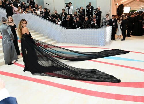 Rita Ora Makes a Case for Sheer on Met Gala Red Carpet 2023 in Prabal Gurung Dress & Strappy Sandals With Taika Waititi

Rita Ora arrived at the 2023 Met Gala in New York wearing an all-black ensemble. The singer posed on the carpet with her husband, director Taika Waititi.

Ora donned a daring outfit that featured detailed draping, striking cutouts and well-defined boning from Prabal Gurung.

The Nepalese-American fashion designer has been a fixture at the Met Gala since 2010. His designs have graced the red carpet, showcasing his signature style that often combines traditional Nepalese influences with modern, edgy elements. He has dressed a range of celebrities, from Sarah Jessica Parker to Zendaya over the years.

Regarding her footwear choice, Ora strapped on a pair of strappy sandals with a generous platform. These strappy platform sandals feature a chic ankle buckle closure that provides a secure fit. The almond toe design adds a touch of elegance, while the 6-inch heel elongates the legs and creates a flattering silhouette.

Ora’s fashion style is a mix of edgy and glamorous, often pushing boundaries with bold statement pieces. She is known for wearing daring outfits that showcase her confident and daring personality. Rita has also been a standout at the Met Gala, consistently impressing with her unique and avant-garde choices. From her bold silver feathered gown in 2016 to her Prada moment in 2021, she always manages to turn heads on the red carpet.

The Met Gala raises funds for the Metropolitan Museum of Art in New York City and celebrates the Costume Institute’s annual exhibits. This year’s theme, “Karl Lagerfeld: A Line of Beauty,” celebrates the life and career of designer Karl Lagerfeld. The 2023 event is notably co-chaired by Dua Lipa, Roger Federer, Michaela Coel, Penelope Cruz and Vogue editor-in-chief Anna Wintour.

Rita Ora attends The 2023 Met Gala Celebrating "Karl Lagerfeld: A Line Of Beauty" at The Metropolitan Museum of Art on May 01, 2023 in New York City.

Met Gala 2023: Rita Ora sizzles in a black sheer gown as she joins dapper husband Taika Waititi on the star-studded red carpet.

Rita Ora brought the goth glamour to the Met Gala 2023 red carpet with a sheer corseted gown by Prabal Gurung.

#RitaOra #2023MetGala