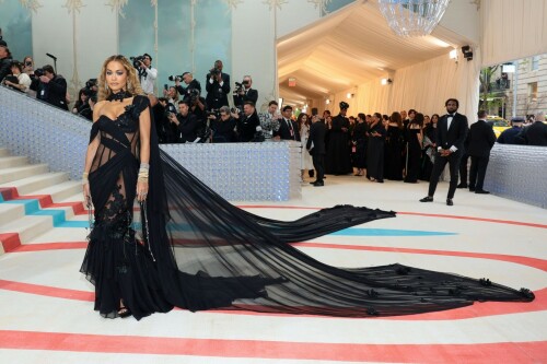 Met Gala 2023: Rita Ora Is Serving Fashion Witch at The Met Gala

May shmay! It's spooky season for Rita.

Fifty Shades of Grey actor Rita Ora arrived at the 2023 Met Gala in a witchy and bewitching gown that makes us feel incredibly October given that it's May. Is she vying for a part on her beau Taika Waititi's What We Do in the Shadows? Very much still in her boudoir fashion era. It's not not lingerie.

Ora's Prabal Gurung gown for the event plays with sheer and with layers, two elements she's been wearing a lot lately, but it's the nails and train that really stand out. Her long black…cloak? Cape? Scarf? covered nearly the length of the blue, white, and red carpet, creating a dramatic silhouette and, frankly, giving her a moment to get all camera lenses on her.

Equally decadent were the jewels literally dripping from her fingertips, as glittering ropes cascaded from her nails. Okay but like, how's she gonna eat dinner inside?

The smoky eye will never die. But combined with the lined lips? It's the new classics.

Ora reflected on the night's theme—"Karl Lagerfeld: A Line of Beauty"—on Instagram, sharing two posts in honor of the late designer. In the first, she and Lagerfeld pose together at various events, she walks the runway in a silver ensemble, and wears his designs for Chanel in various shoots.

In the second photo roundup, seemingly taken recently (peep the nails), Ora plays around in an old costume made by Karl himself. "In memory of Karl I had to bring back this custom piece he made me for a Chanel show performance I did with him in Monaco back in 2013. See you tomorrow!!" the singer wrote.

It's not that this doesn't go with the theme—the flowers and the black are totally Lagerfeldian—but anyone else think this is what she would have worn no matter what?

Rita Ora attends The 2023 Met Gala Celebrating "Karl Lagerfeld: A Line Of Beauty" at The Metropolitan Museum of Art on May 01, 2023 in New York City.

Met Gala 2023: Rita Ora sizzles in a black sheer gown as she joins dapper husband Taika Waititi on the star-studded red carpet.

Rita Ora brought the goth glamour to the Met Gala 2023 red carpet with a sheer corseted gown by Prabal Gurung.

#RitaOra #2023MetGala