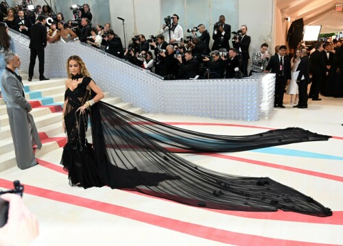 Rita Ora Makes a Case for Sheer on Met Gala Red Carpet 2023 in Prabal Gurung Dress & Strappy Sandals With Taika Waititi

Rita Ora arrived at the 2023 Met Gala in New York wearing an all-black ensemble. The singer posed on the carpet with her husband, director Taika Waititi.

Ora donned a daring outfit that featured detailed draping, striking cutouts and well-defined boning from Prabal Gurung.

The Nepalese-American fashion designer has been a fixture at the Met Gala since 2010. His designs have graced the red carpet, showcasing his signature style that often combines traditional Nepalese influences with modern, edgy elements. He has dressed a range of celebrities, from Sarah Jessica Parker to Zendaya over the years.

Regarding her footwear choice, Ora strapped on a pair of strappy sandals with a generous platform. These strappy platform sandals feature a chic ankle buckle closure that provides a secure fit. The almond toe design adds a touch of elegance, while the 6-inch heel elongates the legs and creates a flattering silhouette.

Ora’s fashion style is a mix of edgy and glamorous, often pushing boundaries with bold statement pieces. She is known for wearing daring outfits that showcase her confident and daring personality. Rita has also been a standout at the Met Gala, consistently impressing with her unique and avant-garde choices. From her bold silver feathered gown in 2016 to her Prada moment in 2021, she always manages to turn heads on the red carpet.

The Met Gala raises funds for the Metropolitan Museum of Art in New York City and celebrates the Costume Institute’s annual exhibits. This year’s theme, “Karl Lagerfeld: A Line of Beauty,” celebrates the life and career of designer Karl Lagerfeld. The 2023 event is notably co-chaired by Dua Lipa, Roger Federer, Michaela Coel, Penelope Cruz and Vogue editor-in-chief Anna Wintour.

Rita Ora attends The 2023 Met Gala Celebrating "Karl Lagerfeld: A Line Of Beauty" at The Metropolitan Museum of Art on May 01, 2023 in New York City.

Met Gala 2023: Rita Ora sizzles in a black sheer gown as she joins dapper husband Taika Waititi on the star-studded red carpet.

Rita Ora brought the goth glamour to the Met Gala 2023 red carpet with a sheer corseted gown by Prabal Gurung.

#RitaOra #2023MetGala