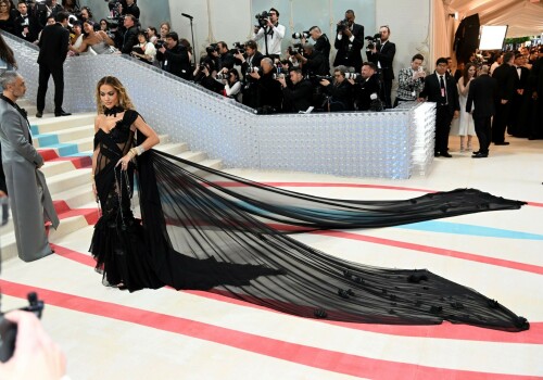 Rita Ora Makes a Case for Sheer on Met Gala Red Carpet 2023 in Prabal Gurung Dress & Strappy Sandals With Taika Waititi

Rita Ora arrived at the 2023 Met Gala in New York wearing an all-black ensemble. The singer posed on the carpet with her husband, director Taika Waititi.

Ora donned a daring outfit that featured detailed draping, striking cutouts and well-defined boning from Prabal Gurung.

The Nepalese-American fashion designer has been a fixture at the Met Gala since 2010. His designs have graced the red carpet, showcasing his signature style that often combines traditional Nepalese influences with modern, edgy elements. He has dressed a range of celebrities, from Sarah Jessica Parker to Zendaya over the years.

Regarding her footwear choice, Ora strapped on a pair of strappy sandals with a generous platform. These strappy platform sandals feature a chic ankle buckle closure that provides a secure fit. The almond toe design adds a touch of elegance, while the 6-inch heel elongates the legs and creates a flattering silhouette.

Ora’s fashion style is a mix of edgy and glamorous, often pushing boundaries with bold statement pieces. She is known for wearing daring outfits that showcase her confident and daring personality. Rita has also been a standout at the Met Gala, consistently impressing with her unique and avant-garde choices. From her bold silver feathered gown in 2016 to her Prada moment in 2021, she always manages to turn heads on the red carpet.

The Met Gala raises funds for the Metropolitan Museum of Art in New York City and celebrates the Costume Institute’s annual exhibits. This year’s theme, “Karl Lagerfeld: A Line of Beauty,” celebrates the life and career of designer Karl Lagerfeld. The 2023 event is notably co-chaired by Dua Lipa, Roger Federer, Michaela Coel, Penelope Cruz and Vogue editor-in-chief Anna Wintour.

Rita Ora attends The 2023 Met Gala Celebrating "Karl Lagerfeld: A Line Of Beauty" at The Metropolitan Museum of Art on May 01, 2023 in New York City.

Met Gala 2023: Rita Ora sizzles in a black sheer gown as she joins dapper husband Taika Waititi on the star-studded red carpet.

Rita Ora brought the goth glamour to the Met Gala 2023 red carpet with a sheer corseted gown by Prabal Gurung.

#RitaOra #2023MetGala