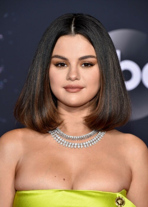 Selena Gomez Shines Bright in Versace at the 2019 American Music Awards

Selena Gomez shined bright on the red carpet of the 2019 American Music Awards on Sunday, November 24, at Los Angeles’ Microsoft Theater.

The I Can’t Get Enough singer stunned in a strapless chartreuse Versace minidress with a ruffle detail and gold buttons running down along the side. She accessorized the look with perfectly matching neon green pumps and a Roberto Coin diamond and platinum Pharaoh necklace. The look was styled by Kate Young.

Her lime green ensemble wasn’t the only thing that had Us turning heads: She also exchanged her signature long tresses for a chic, shoulder length bob, created by longtime hair pro Marissa Marino. The lob featured fresh curled-under ends with major volume and bounce.

As for makeup, Gomez literally glowed on the red carpet thanks to golden-bronze eyeshadow, lined lids and matte nude lips done by the singer’s steady makeup artist Hung Vanngo.

Gomez, 27, opened the award show singing new music “Lose You to Love Me” and “Look at Her Now” in a silver mirrored gown and added silver glitter and black lined rims to her eye makeup. She also updated her lob with bent waves.

Gomez previously opened the AMAs in 2014, 2015 and most recently, in 2017, when she sang her song “Wolves.” This marks her first live performance in two years.

In October, the songstress released “Lose You to Love Me,” a ballad about her relationship with ex-boyfriend Justin Bieber, whom she dated on and off from 2011 to 2018. A source told Us Weekly at the time that gut-wrenching track was “inspired” by her breakup with the “What Do You Mean?” singer.

Also taking the stage is Gomez’s BFF, Taylor Swift. Swift, who is being honored with artist of the decade, has found herself in the center of some drama ahead of her own performance. Earlier this month, the pop star called out music manager Scooter Braun and Big Machine Records CEO Scott Borchetta, claiming they were blocking her from performing any of her older songs from her back catalog at the ABC show.

Gomez was one of the first to speak out in support of the “Lover” songstress.

usmagazine.com

#SelenaGomez