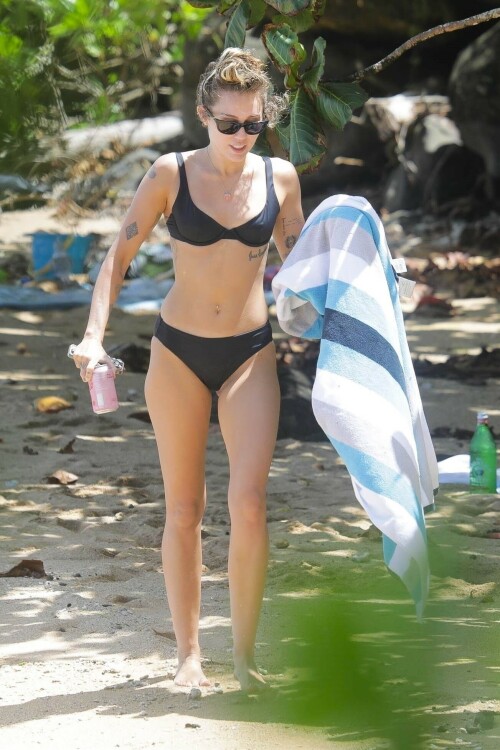 Miley Cyrus in a black bikini in Hawaii - September 6, 2023

Miley Cyrus flaunts her toned figure in a black bikini on the beach in Hawaii during mom Tish's honeymoon with Dominic Purcell

Miley Cyrus appears to be in the best shape of her life these days.

The crooner from Tennessee was seen showing off her very toned and slender figure in a skimpy black bikini that revealed her array of tattoos as well as her belly piercing while on the beach in Hawaii.

The 30-year-old daughter of Billy Ray Cyrus and Tish Cyrus was enjoying some down time in the sun while on the shores of the big island.

The star was with her mom Tish as she had fun with new husband Dominic Purcell during their seaside honeymoon.

Also spied was Miley's beau Maxx Morando, 24, who wore black swim trunks.

This comes after a very busy schedule where the Hannah Montana veteran was promoting her new nostalgic song Used To Be Young. The tune, which Adele praised, looks back at her life as a wild teen who was trying to carve out her career as a solo performer.

Before joining the four-person Los Angeles rock band Lilly, Morando played drums for punk rock band The Regrettes from 2015 to 2018.

He and Cyrus have many mutual friends in common and have known one another as friends for many years.

Miley had fun while on the shore as she took a stab at snorkeling. She was seen with the eye mask and neon green tube on her head as she added long dark flippers on her feet.

She was in and out of the water, later holding a colorful towel.

It has been quite the year for her mom Tish. She married Prison Break star Purcell at an intimate ceremony in California in mid August. The couple tied the knot after announcing their engagement in May after Tish's shock divorce from Billy Ray in 2022.

It was an intimate affair with just 60 people attending the lavish ceremony that was held in Tish's megastar daughter Miley's house in Malibu.

Included in the small guestlist was Australian cricket star David Warner and his wife Candice.

David has been friends with Dominic for over 15 years, so he flew to the US with Candice to celebrate his new love.

Speaking to Daily Mail Australia, Candice said the wedding was 'absolutely beautiful' and it was clear that Tish and Dominic are madly in love.

'It was just magical, there were fairy lights in the trees and beautiful tables with beautiful flower arrangements,' she said.

'It was a small wedding with 60 at the ceremony and a little bit more afterwards but Tish walked out and had her daughters by her side Miley and Brandi and they were so happy for their mother, they were in tears and holding her hand the whole night.'

Tish was married to Billy Ray Cyrus for 28 years and they share three children together- Miley, 30, Braison, 29, and Noah, 23.

Billy Ray also adopted Tish's two children from her previous marriage- Brandi, 36, and Metro Station singer Trace, 34.

Dominic was married to Rebecca Williamson from 1998 until 2008, and they share four children together- Joseph, 24, Audrey, 22 and twins Lily-Rose and Augustus, 20.

Candice said it was beautiful to see Tish, 56, and Dominic, 53, find love again.

'Tish and Dom are so happy. At an age where some people think they may never find true love again it was really beautiful,' she said.

Candice said Miley didn't perform on the night, but Tish walked out to one of her songs and it was apparent that the popstar was so happy for her mother.

Miley has been working hard this summer to plug her new song Used To Be Young.

Last week she did an interview where she walked down memory lane.

During the Disney vet's chat she pulled up an old photo from the premiere of Hannah Montana The Movie which took place in 2009.

The daughter of country star Billy Ray Cyrus was walking with Hannah Montana star Emily Osment as well as singers Taylor Swift and Demi Lovato.

Cyrus was dressed down in a cardigan, two tank tops, loose slacks and comfortable looking UGG boots with bedazzled peace signs. Her famous pals were glammed up in fancy dresses and high heels.

The songbird says this proves that she was bisexual. Miley shared the clip to TikTok.

'If you guys didn't know I was bisexual from this damn picture, I don't know what's wrong with you,' the star said.

'I mean hello!' she added. 'Look at 'em!'

She said the image was taken after the premiere and they were going to a Los Angeles restaurant chain.

'Me and Emily and Taylor Swift and Demi Lovato are going to The Cheesecake Factory,' she shared. 'These are some classy ladies.'

In 2016 to come out as pansexual.

'My whole life, I didn't understand my own gender and my own sexuality. I always hated the word bisexual, because that's even putting me in a box,' she explained during in Variety.

'I don't ever think about someone being a boy or someone being a girl. Myeyes started opening in the fifth or sixth grade.'

Then she met someone who didn't see themselves as a man or woman.

That is when she had a moment.

'I related to that person more than I related to anyone in my life,' Cyrus explained. 'I understood my sexuality more. I was like, Oh — that's why I don't feel straight and I don't feel gay. It's because I'm not.'

Also this week she looked back at falling in love with her ex-husband Liam Hemsworth as teenagers while filming The Last Song in 2008.

While recalling their fateful meeting during a new video for her Used to Be Young series on TikTok, the 30-year-old pop star gushed about how their off-stage romance made their coming-of-age drama, based on the novel by Nicholas Sparks, 'feel so special.'

'In 2008, I needed to do another feature film for Disney and I didn't want it to be a part of Hannah Montana,' she told her followers. 'Once we had written the screenplay, it was time to audition all the guys who would play Will, my boyfriend in the movie.'

After narrowing down the pool from thousands, the Malibu hitmaker said 'Liam was a part of that final three.'

'I think one of the elements that made that movie feel so special was it was watching two very young people fall in love with each other, which was happening in real time and in real life,' she continued.

The two-time Grammy nominee gushed that their 'chemistry was undeniable' to viewers.

'That was the beginning of a long 10-year relationship,' she mused, referring to their passionate, on-and-off relationship, which led to two engagements and an eight-month marriage.

The video comes just three days after she opened up about their 'magical' home in Malibu, which was burnt down in a devastating wildfire in 2018.

'That house had so much magic to it that it ended up really changing my life,' Cyrus reminisced.

The singer went on to note that she recorded her debut 2007 album, Meet Miley Cyrus, at the house, where producer Matthew Wilder was living at the time, not knowing the house would be hers years later.

The record helped Miley bridge the gap between her solo music career and her starring role on Disney Channel's Hannah Montana.

'The Meet Miley Cyrus record was really where I started writing my own songs as a solo artist,' Miley explained.

She also said this week that she was filming Black Mirror when her house burned down.

The star has reflected on being in South Africa shooting scenes for her role as Ashley O in the 'Rachel, Jack and Ashley Too' episode of the Netflix anthology sci-fi horror series when her $2.525 million Malibu home burned down in the 2018 Woolsey fire.

Speaking in her new TikTok series Used To Be Young, she said: 'I was in South Africa, but it was taking place in Malibu. So it was just a real trip.

'Like probably two or three years later after this happened, I didn't understand, but I would have this anxiety attack with the vision attached that I would be strapped down to a gurney.

The day after her home was destroyed in the blaze, she was on set filming her pop star character's 'On A Roll' fictional music video.

She added: 'The show must go on.'

The hitmaker lived in the property with her Hemsworth before it burned down in the California wildfires nearly five years ago, and in spite of their split, Miley still has very fond memories of living there.

She said in a recent TikTok video: 'The Meet Miley Cyrus record was really where I started writing my own songs as a solo artist.

'And so I was working with a producer in Malibu that lived in a house in Ramirez Canyon, which I would've never known 15 years later I would be living in that house, which would eventually burn down.

'That house had so much magic to it. It ended up really changing my life.'

DailyMail

#MileyCyrus