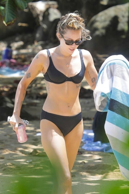 Miley Cyrus in a black bikini in Hawaii - September 6, 2023

Miley Cyrus flaunts her toned figure in a black bikini on the beach in Hawaii during mom Tish's honeymoon with Dominic Purcell

Miley Cyrus appears to be in the best shape of her life these days.

The crooner from Tennessee was seen showing off her very toned and slender figure in a skimpy black bikini that revealed her array of tattoos as well as her belly piercing while on the beach in Hawaii.

The 30-year-old daughter of Billy Ray Cyrus and Tish Cyrus was enjoying some down time in the sun while on the shores of the big island.

The star was with her mom Tish as she had fun with new husband Dominic Purcell during their seaside honeymoon.

Also spied was Miley's beau Maxx Morando, 24, who wore black swim trunks. 

This comes after a very busy schedule where the Hannah Montana veteran was promoting her new nostalgic song Used To Be Young. The tune, which Adele praised, looks back at her life as a wild teen who was trying to carve out her career as a solo performer.

Before joining the four-person Los Angeles rock band Lilly, Morando played drums for punk rock band The Regrettes from 2015 to 2018.

He and Cyrus have many mutual friends in common and have known one another as friends for many years.

Miley had fun while on the shore as she took a stab at snorkeling. She was seen with the eye mask and neon green tube on her head as she added long dark flippers on her feet.

She was in and out of the water, later holding a colorful towel.

It has been quite the year for her mom Tish. She married Prison Break star Purcell at an intimate ceremony in California in mid August. The couple tied the knot after announcing their engagement in May after Tish's shock divorce from Billy Ray in 2022. 

It was an intimate affair with just 60 people attending the lavish ceremony that was held in Tish's megastar daughter Miley's house in Malibu. 

Included in the small guestlist was Australian cricket star David Warner and his wife Candice. 

David has been friends with Dominic for over 15 years, so he flew to the US with Candice to celebrate his new love.   

Speaking to Daily Mail Australia, Candice said the wedding was 'absolutely beautiful' and it was clear that Tish and Dominic are madly in love. 

'It was just magical, there were fairy lights in the trees and beautiful tables with beautiful flower arrangements,' she said. 

'It was a small wedding with 60 at the ceremony and a little bit more afterwards but Tish walked out and had her daughters by her side Miley and Brandi and they were so happy for their mother, they were in tears and holding her hand the whole night.'

Tish was married to Billy Ray Cyrus for 28 years and they share three children together- Miley, 30, Braison, 29, and Noah, 23. 

Billy Ray also adopted Tish's two children from her previous marriage- Brandi, 36, and Metro Station singer Trace, 34. 

Dominic was married to Rebecca Williamson from 1998 until 2008, and they share four children together- Joseph, 24, Audrey, 22 and twins Lily-Rose and Augustus, 20.  

Candice said it was beautiful to see Tish, 56, and Dominic, 53, find love again.

'Tish and Dom are so happy. At an age where some people think they may never find true love again it was really beautiful,' she said. 

Candice said Miley didn't perform on the night, but Tish walked out to one of her songs and it was apparent that the popstar was so happy for her mother.   

Miley has been working hard this summer to plug her new song Used To Be Young. 

Last week she did an interview where she walked down memory lane.

During the Disney vet's chat she pulled up an old photo from the premiere of Hannah Montana The Movie which took place in 2009.

The daughter of country star Billy Ray Cyrus was walking with Hannah Montana star Emily Osment as well as singers Taylor Swift and Demi Lovato.

Cyrus was dressed down in a cardigan, two tank tops, loose slacks and comfortable looking UGG boots with bedazzled peace signs. Her famous pals were glammed up in fancy dresses and high heels.

The songbird says this proves that she was bisexual. Miley shared the clip to TikTok.

'If you guys didn't know I was bisexual from this damn picture, I don't know what's wrong with you,' the star said.

'I mean hello!' she added. 'Look at 'em!'

She said the image was taken after the premiere and they were going to a Los Angeles restaurant chain.

'Me and Emily and Taylor Swift and Demi Lovato are going to The Cheesecake Factory,' she shared. 'These are some classy ladies.'

In 2016 to come out as pansexual.

'My whole life, I didn't understand my own gender and my own sexuality. I always hated the word bisexual, because that's even putting me in a box,' she explained during in Variety.

'I don't ever think about someone being a boy or someone being a girl. Myeyes started opening in the fifth or sixth grade.'

Then she met someone who didn't see themselves as a man or woman.

That is when she had a moment.

'I related to that person more than I related to anyone in my life,' Cyrus explained. 'I understood my sexuality more. I was like, Oh — that's why I don't feel straight and I don't feel gay. It's because I'm not.'

Also this week she looked back at falling in love with her ex-husband Liam Hemsworth as teenagers while filming The Last Song in 2008.

While recalling their fateful meeting during a new video for her Used to Be Young series on TikTok, the 30-year-old pop star gushed about how their off-stage romance made their coming-of-age drama, based on the novel by Nicholas Sparks, 'feel so special.'

'In 2008, I needed to do another feature film for Disney and I didn't want it to be a part of Hannah Montana,' she told her followers. 'Once we had written the screenplay, it was time to audition all the guys who would play Will, my boyfriend in the movie.'

After narrowing down the pool from thousands, the Malibu hitmaker said 'Liam was a part of that final three.' 

'I think one of the elements that made that movie feel so special was it was watching two very young people fall in love with each other, which was happening in real time and in real life,' she continued. 

The two-time Grammy nominee gushed that their 'chemistry was undeniable' to viewers.  

'That was the beginning of a long 10-year relationship,' she mused, referring to their passionate, on-and-off relationship, which led to two engagements and an eight-month marriage.

The video comes just three days after she opened up about their 'magical' home in Malibu, which was burnt down in a devastating wildfire in 2018. 

'That house had so much magic to it that it ended up really changing my life,' Cyrus reminisced. 

The singer went on to note that she recorded her debut 2007 album, Meet Miley Cyrus, at the house, where producer Matthew Wilder was living at the time, not knowing the house would be hers years later. 

The record helped Miley bridge the gap between her solo music career and her starring role on Disney Channel's Hannah Montana.

'The Meet Miley Cyrus record was really where I started writing my own songs as a solo artist,' Miley explained.

She also said this week that she was filming Black Mirror when her house burned down.

The  star has reflected on being in South Africa shooting scenes for her role as Ashley O in the 'Rachel, Jack and Ashley Too' episode of the Netflix anthology sci-fi horror series when her $2.525 million Malibu home burned down in the 2018 Woolsey fire.

Speaking in her new TikTok series Used To Be Young, she said: 'I was in South Africa, but it was taking place in Malibu. So it was just a real trip.

'Like probably two or three years later after this happened, I didn't understand, but I would have this anxiety attack with the vision attached that I would be strapped down to a gurney.

The day after her home was destroyed in the blaze, she was on set filming her pop star character's 'On A Roll' fictional music video.

She added: 'The show must go on.'

The hitmaker lived in the property with her Hemsworth before it burned down in the California wildfires nearly five years ago, and in spite of their split, Miley still has very fond memories of living there.

She said in a recent TikTok video: 'The Meet Miley Cyrus record was really where I started writing my own songs as a solo artist. 

'And so I was working with a producer in Malibu that lived in a house in Ramirez Canyon, which I would've never known 15 years later I would be living in that house, which would eventually burn down.

'That house had so much magic to it. It ended up really changing my life.'

DailyMail

#MileyCyrus