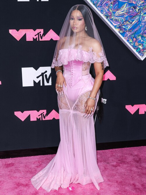 Nicki Minaj | 2023 MTV Video Music Awards in Newark, New Jersey - September 12, 2023

Nicki Minaj Is a Bridal Barbie at the 2023 MTV VMAs

She channeled romance while returning to host this year’s show

Nicki Minaj returned to her Barbiecore roots at the 2023 MTV Video Music Awards.

The rapper—who dubbed herself “Barbie” long before the doll took over the globe this year—made a grand appearance on this year’s red carpet at the Prudential Center in Newark, New Jersey. The star put her own romantic spin on lingerie dressing in a pale pink gown by Dolce & Gabbana, which featured a strapless satin bodysuit and a sheer lace mermaid skirt that fanned out into a circular train. A matching see-through veil with lace trim completed the look.

The rapper finished the monochromatic ensemble with floral-shaped earrings, a diamond tennis bracelet, and an array of diamond rings. Her opulent glam look included a sparkling eye look with pink shadow and sharp cat-eye liner, as well as a nude lip and extra-long bejeweled pink nails.

Minaj is up for six awards tonight, including Artist of the Year and Video of the Year. The host is also set to take the stage twice to perform, both as a solo act and as part of the night’s tribute to hip-hop’s 50th anniversary. For the latter, she will join Lil Wayne, Darryl “DMC” McDaniels, Doug E. Fresh, Grandmaster Flash and the Furious Five, and LL Cool J.

At last year’s awards, Minaj received the Video Vanguard Award and treated the audience to a mash-up performance of hits including “Monster,” “Moment 4 Life,” and “Anaconda.” She transformed the VMAs stage into a Barbie DreamHouse in a tribute to her fans, the Barbz, complete with a matching Barbiecore look composed of a bedazzled corset with crystal-covered sleeves, a flared light-pink skirt, and black platform boots with hot-pink laces.

harpersbazaar

#NickiMinaj #vmas