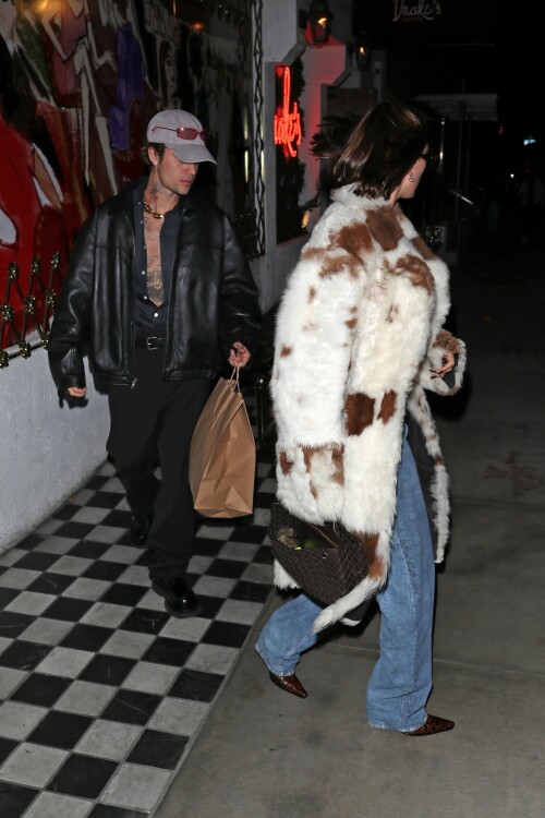 Hailey Bieber & Justin Bieber step out after dinner date at Drake's Restaurant in Los Angeles - November 8, 2023

Justin Bieber unbuttons his shirt exposing his heavily tattooed chest as he follows wife Hailey out of Drake's restaurant in Los Angeles

Justin Bieber and his wife Hailey Bieber were spotted after enjoying a dinner date at Drake's in Los Angeles on Tuesday evening.

The singer, 29, wore his satin top unbuttoned so low that it exposed his heavily tattooed chest.
He also sported an oversize bomber jacket, silky dress pants, and patent leather boots for the special occasion.

The Peaches hitmaker — who wore a Flintstones-inspired couple's costume with the Rhode founder for a Halloween bash — accessorized with a light gray baseball cap and rose-tinted sunglasses on top of his hat.

He also wore massive diamond earrings a d a flashy gold chain on his neck.

His 26-year-old wife had on a furry coat with jeans.

He was spotted carrying a large paper bag, presumably with some leftovers to take home, as he followed closely behind Hailey.

The internet personality bundled up for their cozy dinner date in a cream fur coat with brown spots.

Underneath the eye-catching outwear, she opted for an otherwise casual ensemble with a white cropped T-shirt and low-rise, bootcut jeans.

To match the details in her fur coat, she wore a pair of brown leather, pointed-toe shoes.

For jewelry, she opted for just a pair of massive, dazzling diamond stud earrings.

She also carried a woven box bag in a similar coffee-colored shade and slim, oval sunglasses.

For their evening plans, she left her brunette bob down in a shiny, straight hairstyle.

Hailey looked radiant in a dewy makeup look with a rosy pink blush and glossy mauve pink pout.

The couple — who tied the knot in 2018 — are regularly trolled for wearing juxtaposing styles when out together.

Hailey recently spoke out about why they often appear in opposite outfits, and she blamed the fact they get ready at different times.

In response to a question about how they often look like they are from 'two separate planets', she told GQ Hype that it's because Justin typically gets ready first.

'It's so funny because I see so many people talk about this,' she said.

'He may want to wear baggy sweats to dinner,' she added. 'And I might want to wear a tiny little dress just because that's how I'm feeling.

DailyMail

#HaileyBaldwin #HaileyBieber #JustinBieber