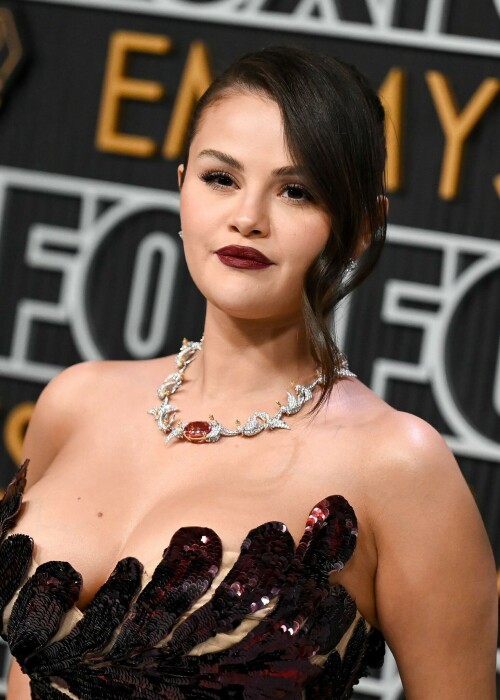 Selena Gomez | 75th Primetime Emmy Awards at the Peacock Theater in LA - 15.01.2024

Selena Gomez Shines on Emmys Red Carpet as Benny Blanco Blows Her a Kiss

Gomez looked glamorous in a custom Oscar de la Renta dress.

Selena Gomez, whose hit television series Only Murders in the Building is nominated for best comedy at the Emmy Awards, arrived on the red carpet with Benny Blanco Monday (Jan. 15).

While the the pair didn’t officially pose together, Blanco wasn’t far from Gomez’s side. As the pop star/actress stepped forward to be photographed, Blanco blew a kiss her way before walking away from the carpet.

Gomez looked glamorous in a formfitting, dark red Oscar de la Renta dress with a scalloped neckline and strappy black heels. The custom dress is made up of more than 450,000 pailletes and required 930 hours of hand embroidery, according to Oscar de la Renta. Her hair was swept back in an updo, with a loose, pretty wave grazing the side of her face, and her makeup featured a burgundy lip that complemented her elegant ensemble.

The Only Murders in the Building star first confirmed she and Blanco were an item on Dec. 7, half a year after the pair are believed to have started dating. She told fans in on Instagram that the producer is “my absolute everything in my heart” and that she’s at her “happiest” in the relationship.

Watch the couple’s sweet red carpet moment in a clip from E! below, and see them find their seats together in a video from The Hollywood Reporter. Plus, see a photo of Gomez’s full look, styled by Erin Walsh.

billboard

#SelenaGomez