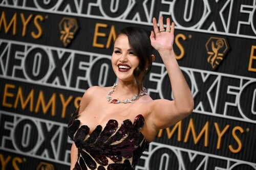 Selena Gomez | 75th Primetime Emmy Awards at the Peacock Theater in LA - 15.01.2024

Selena Gomez Shines on Emmys Red Carpet as Benny Blanco Blows Her a Kiss

Gomez looked glamorous in a custom Oscar de la Renta dress.

Selena Gomez, whose hit television series Only Murders in the Building is nominated for best comedy at the Emmy Awards, arrived on the red carpet with Benny Blanco Monday (Jan. 15).

While the the pair didn’t officially pose together, Blanco wasn’t far from Gomez’s side. As the pop star/actress stepped forward to be photographed, Blanco blew a kiss her way before walking away from the carpet.

Gomez looked glamorous in a formfitting, dark red Oscar de la Renta dress with a scalloped neckline and strappy black heels. The custom dress is made up of more than 450,000 pailletes and required 930 hours of hand embroidery, according to Oscar de la Renta. Her hair was swept back in an updo, with a loose, pretty wave grazing the side of her face, and her makeup featured a burgundy lip that complemented her elegant ensemble.

The Only Murders in the Building star first confirmed she and Blanco were an item on Dec. 7, half a year after the pair are believed to have started dating. She told fans in on Instagram that the producer is “my absolute everything in my heart” and that she’s at her “happiest” in the relationship.

Watch the couple’s sweet red carpet moment in a clip from E! below, and see them find their seats together in a video from The Hollywood Reporter. Plus, see a photo of Gomez’s full look, styled by Erin Walsh.

billboard

#SelenaGomez