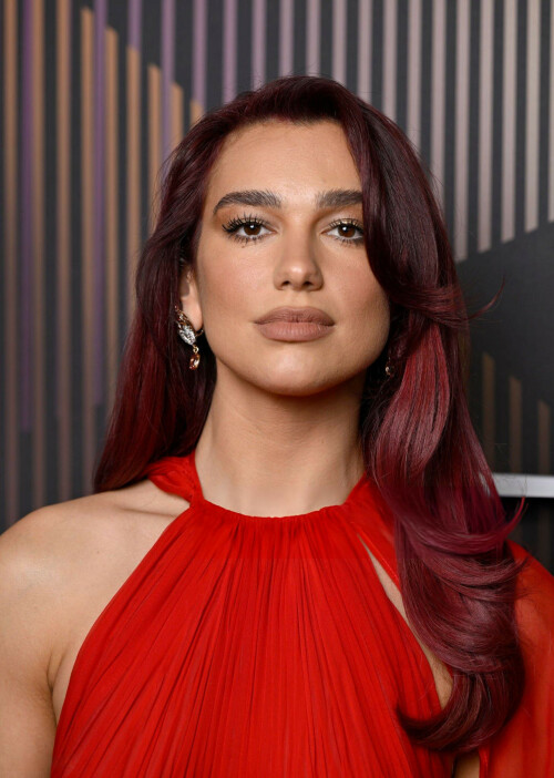 Dua Lipa at the EE BAFTA Film Awards 2024 at The Royal Festival Hall - 18.02.2024

Dua Lipa Wore a Statement-Making Red Gown and Cape on the 2024 BAFTA Awards Red Carpet

The only thing more fiery than the “Dance the Night” singer’s hair was her ensemble.

Dua Lipa certainly knows how to make a red carpet statement.

The "Levitating" singer walked the 2024 EE BAFTA Film Awards red carpet in a show-stopping floor-length red gown featuring a matching red cape that seemed to go on for miles.

The halterneck-pleated gown showed off Lipa's minimal arm tattoos and was free-flowing with a semi-cinched waist. The singer finished the look with minimal makeup that perfectly complimented not only her gown and semi-sheer cape but her purple and red fire-inspired hair.

Forever fashionable, Lipa's all-red ensemble continued the trend of all-red ensembles during the 2024 award season... and we certainly are here for it.

While silver looks were all the rage this year, more than a few A-list celebrities decided to go with an all-red look this awards season, especially during the 2024 Emmy Awards.

Suki Waterhouse, for example, co-signed the trend in a red Valentino gown featuring side cutouts that highlighted her pregnant belly.

Award-winning Succession star Sarah Snook also leaned into the trend during the Emmy Awards with a voluminous Vivienne Westwood ensemble that certainly honored Old Hollywood glam. The gown featured a corset-style bodice and sweeping skirt, and was paired with a stunning jewel necklace and diamond earrings.

While many celebrities have adopted the all-red trend this year, Lipa has certainly gone all-in with the addition of her fiery, cherry-red hair color.

Hairstylist Ben Gregory—who has helped Lipa play with her redhead looks—talked to Marie Claire exclusively about her updated, totally "in" look.

"We were having conversations about her new era and the next chapter. She was thinking about changing her hair," the UK-based hairstylist said. "The thing with Dua is that she’s such a beautiful, powerful-looking woman. She’s reminiscent in many ways of that old-school supermodel. They put her in the Chanel Claudia Schiffer gown for the Met, and there's a reason for that. She walks a line between being this fashion figure and a music artist for me. She has this old-school supermodel sexiness about her, but she’s also super young, contemporary, and cool."

marieclaire

#DuaLipa #BAFTAs