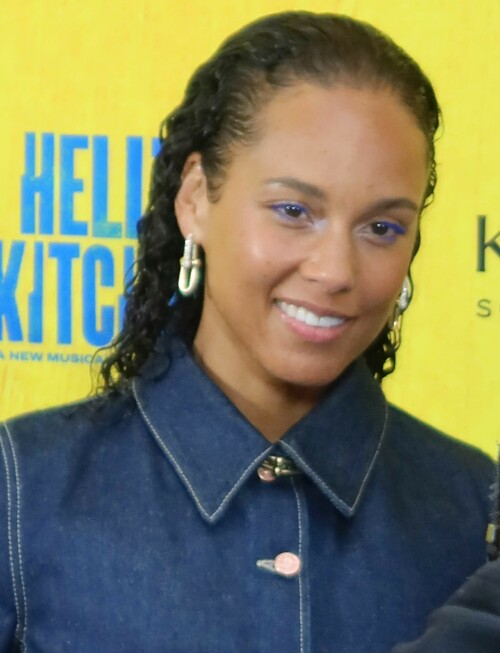 Alicia Keys | Opening night of the new Alicia Keys Musical 'Hell's Kitchen', NYC - 20.04.2024

13 HQ pics: http://kosty555.info/index.php?showtopic=306830

‘Hell’s Kitchen’ Review: Alicia Keys Musical Brings a Vibrant Depiction of Teen Girlhood to Broadway

“Hell’s Kitchen” opened on Broadway on April 20, 2024. The following is Aramide Tinubu’s review of the show’s Off Broadway premiere published on Nov. 19, 2023. The credits and copy have been updated to reflect any changes for the Broadway transfer.

“Hell’s Kitchen,” playwright Kristoffer Diaz‘s new musical with songs by Alicia Keys, begins at a dinner table. 17-year-old Ali (a magnetic Maleah Joi Moon, making her professional debut) has dinner with her mom, Jersey (Shoshana Bean), in their Hell’s Kitchen apartment every night at the same time. It’s a routine that Jersey insists on to keep Ali safe from the perils of New York City in the 1990s. But for Ali, their one-bedroom apartment on the 42nd floor feels like a cage. She longs to hang out with her friends, listen to music and flirt with an older drummer named Knuck (Chris Lee), who uses the courtyard of their Manhattan Plaza building as his stage.

Styled in baggie jeans, Timberland boots, Tommy Hilfiger crop tops and gold chains, Ali speaks directly to the audience about her feelings, dreams and desires. She welcomes viewers into her beautifully chaotic teenage world as if opening up her diary. Without an outlet to express herself, she comments on her increasing frustrations with Jersey’s overbearing attitude while gathering the courage to approach Knuck.

It’s difficult to unlock the experience of being a 17-year-old girl, but under Michael Greif‘s direction, “Hell’s Kitchen” does just that. Loosely based on Grammy Award winner Keys’ personal experiences, the musical, now playing on Broadway after a world premiere last year at the Public Theater, captures Ali’s ever-evolving emotions and her quest for freedom. Despite her mother’s rules, Ali rebels against them, staying out late, getting to know Knuck intimately and fighting Jersey at every turn.

Because her estranged father, Davis (Brandon Victor Dixon), is a professional musician, Ali only begrudgingly learns to play the piano from her stern neighbor, Miss Lisa Jane (Kecia Lewis). But soon she discovers that music might be the best way to convey her feelings.

With absolute powerhouse vocals from the cast and songs written by Keys with orchestrations and arrangements by Emmy and Grammy winner Adam Blackstone, “Hell’s Kitchen” moves beyond Ali’s teenage experiences. The play also showcases Jersey’s perspective as a single mother determined to get her daughter to make different choices from her own. Though Keys’ iconic music is used throughout, Diaz and Blackstone don’t haphazardly sprinkle the tunes across two acts. Instead, tracks like “You Don’t Know My Name” and “Fallin” come thundering forward from surprising characters at unexpected times.

The set design, though simple, captures the essence of New York City. Designer Robert Brill uses black steel rectangles to showcase the city’s vertical structures and linear lines. Image projection is used in the background to orient the audience in a specific neighborhood or place. The minimalism of the stage and Ali’s earnest narration make the viewers feel a part of the production rather than just spectators.

In addition to Moon and Bean’s sensational vocal range, “Hell’s Kitchen” illustrates how tender mother/daughter relationships can be. It also reflects the issues underlying New York City in the ’90s while demonstrating the impact of loss, absentee fathers and over-policing in communities of color. Since the play runs at a lengthy 2 hours and 30 minutes (including an intermission), these themes are often drawn out and sometimes feel cliché, bordering on corny. However, the absolute dynamism of the cast keeps the show from falling into pure melodrama.

Still, “Hell’s Kitchen” is a quintessential musical. Some of the dancing is over-elaborate at times, especially during tender numbers like “Hallelujah/Like Water” or sensual moments including “Un-thinkable (I’m Ready).” While these segments could have shined with the singing alone, the ensemble’s talent is undeniable. With stunning harmonies and the infusion of on-stage pianists, guitarists and drummers, the show feels like watching a glorious tapestry come together.

When it’s all said and done, “Hell’s Kitchen” is more than a story about a young woman’s first love affair. Ali’s involvement with Knuck is a central component, but as one of her homegirls points out, having a man isn’t the sole all-important element of the narrative. Instead, “Hell’s Kitchen” is a sparkling story paying homage to New York, to that beautiful and heartbreaking transition between girlhood and womanhood and to the women who hold our hands through it all.

variety.com

#AliciaKeys
