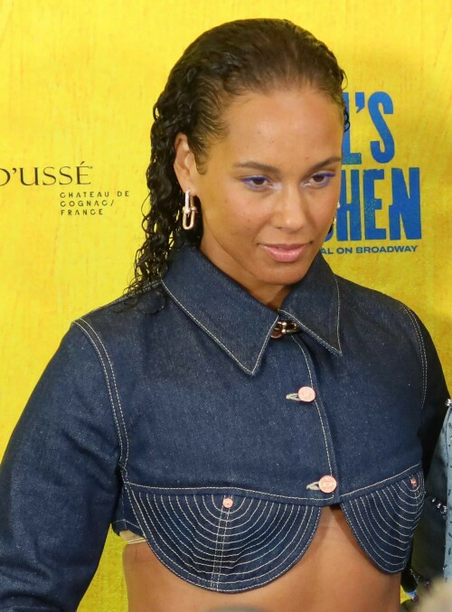 Alicia Keys | Opening night of the new Alicia Keys Musical 'Hell's Kitchen', NYC - 20.04.2024

13 HQ pics: http://kosty555.info/index.php?showtopic=306830

‘Hell’s Kitchen’ Review: Alicia Keys Musical Brings a Vibrant Depiction of Teen Girlhood to Broadway

“Hell’s Kitchen” opened on Broadway on April 20, 2024. The following is Aramide Tinubu’s review of the show’s Off Broadway premiere published on Nov. 19, 2023. The credits and copy have been updated to reflect any changes for the Broadway transfer.

“Hell’s Kitchen,” playwright Kristoffer Diaz‘s new musical with songs by Alicia Keys, begins at a dinner table. 17-year-old Ali (a magnetic Maleah Joi Moon, making her professional debut) has dinner with her mom, Jersey (Shoshana Bean), in their Hell’s Kitchen apartment every night at the same time. It’s a routine that Jersey insists on to keep Ali safe from the perils of New York City in the 1990s. But for Ali, their one-bedroom apartment on the 42nd floor feels like a cage. She longs to hang out with her friends, listen to music and flirt with an older drummer named Knuck (Chris Lee), who uses the courtyard of their Manhattan Plaza building as his stage.

Styled in baggie jeans, Timberland boots, Tommy Hilfiger crop tops and gold chains, Ali speaks directly to the audience about her feelings, dreams and desires. She welcomes viewers into her beautifully chaotic teenage world as if opening up her diary. Without an outlet to express herself, she comments on her increasing frustrations with Jersey’s overbearing attitude while gathering the courage to approach Knuck.

It’s difficult to unlock the experience of being a 17-year-old girl, but under Michael Greif‘s direction, “Hell’s Kitchen” does just that. Loosely based on Grammy Award winner Keys’ personal experiences, the musical, now playing on Broadway after a world premiere last year at the Public Theater, captures Ali’s ever-evolving emotions and her quest for freedom. Despite her mother’s rules, Ali rebels against them, staying out late, getting to know Knuck intimately and fighting Jersey at every turn.

Because her estranged father, Davis (Brandon Victor Dixon), is a professional musician, Ali only begrudgingly learns to play the piano from her stern neighbor, Miss Lisa Jane (Kecia Lewis). But soon she discovers that music might be the best way to convey her feelings.

With absolute powerhouse vocals from the cast and songs written by Keys with orchestrations and arrangements by Emmy and Grammy winner Adam Blackstone, “Hell’s Kitchen” moves beyond Ali’s teenage experiences. The play also showcases Jersey’s perspective as a single mother determined to get her daughter to make different choices from her own. Though Keys’ iconic music is used throughout, Diaz and Blackstone don’t haphazardly sprinkle the tunes across two acts. Instead, tracks like “You Don’t Know My Name” and “Fallin” come thundering forward from surprising characters at unexpected times.

The set design, though simple, captures the essence of New York City. Designer Robert Brill uses black steel rectangles to showcase the city’s vertical structures and linear lines. Image projection is used in the background to orient the audience in a specific neighborhood or place. The minimalism of the stage and Ali’s earnest narration make the viewers feel a part of the production rather than just spectators.

In addition to Moon and Bean’s sensational vocal range, “Hell’s Kitchen” illustrates how tender mother/daughter relationships can be. It also reflects the issues underlying New York City in the ’90s while demonstrating the impact of loss, absentee fathers and over-policing in communities of color. Since the play runs at a lengthy 2 hours and 30 minutes (including an intermission), these themes are often drawn out and sometimes feel cliché, bordering on corny. However, the absolute dynamism of the cast keeps the show from falling into pure melodrama.

Still, “Hell’s Kitchen” is a quintessential musical. Some of the dancing is over-elaborate at times, especially during tender numbers like “Hallelujah/Like Water” or sensual moments including “Un-thinkable (I’m Ready).” While these segments could have shined with the singing alone, the ensemble’s talent is undeniable. With stunning harmonies and the infusion of on-stage pianists, guitarists and drummers, the show feels like watching a glorious tapestry come together.

When it’s all said and done, “Hell’s Kitchen” is more than a story about a young woman’s first love affair. Ali’s involvement with Knuck is a central component, but as one of her homegirls points out, having a man isn’t the sole all-important element of the narrative. Instead, “Hell’s Kitchen” is a sparkling story paying homage to New York, to that beautiful and heartbreaking transition between girlhood and womanhood and to the women who hold our hands through it all.

variety.com

#AliciaKeys