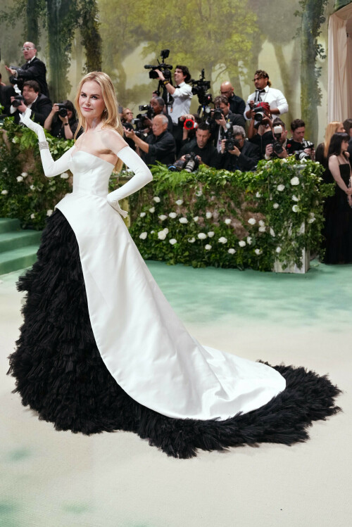 Nicole Kidman attends The 2024 Met Gala Celebrating “Sleeping Beauties: Reawakening Fashion” at The Metropolitan Museum of Art on 06.05.2024, in New York City.

Met Gala 2024: Nicole Kidman Turns Back Time in 1950s-Inspired Balenciaga Gown

Designed by creative director Demna Gvasalia, the dramatic dress is a nod to the original Spanish designer's flamenco-inspired silhouette.

Nicole Kidman certainly turned back the clock in her Balenciaga look at the Met Gala.

Designed by creative director Demna Gvasalia, the Oscar-winning star stepped out in a 1950s-inspired white double silk bustier and flared skirt over frayed layers of black silk organza to mimic feathers. The original gown was inspired by the ruffled dresses worn by flamenco dancers, a nod to Balenciaga’s Spanish heritage.

“It was based on a dress in 1951 by Balenciaga at that time by Cristóbal,” Kidman told La La Anthony on the red carpet. “It was something that I saw in [a Richard] Avedon photo [of Dorian Leigh from Harper’s Bazaar]. I asked Demna if he was willing to reinterpret it. So he reinterpreted it in the vein of the sleeping beauties and the gowns, bringing them back to life. So I consider this to be a ‘Sleeping Beauty’ brought back to life. It’s an honor to be able to bring it back to life.”

Styled by Jason Bolden, Kidman finished her ’50s-inspired look with Harry Winston cluster diamond earrings with approximately 15 carats and the jeweler’s Secret Combination 6-karat diamond bracelet, both set in platinum.

According to Vogue, Kidman’s gown required 800 hours of embroidery to apply the 3,000 organza feathers, and an additional 400 hours to create the white bodice and silk skirt pieces.

At last year’s Karl Lagerfeld-focused fundraiser, Kidman paid homage to her iconic Chanel N°5 perfume campaign in a custom gown by the Parisian fashion house embellished with 250 pink feathers and over 3,000 silver crystals and sequins.

This year’s dress code, “The Garden of Time,” takes its cue from the 1962 short story of the same name by J.G. Ballard, which dovetails nicely with the latest Metropolitan Museum of Art Costume Institute exhibition, Sleeping Beauties: Reawakening Fashion, which opens to the public on Friday, May 10. The Andrew Bolton-curated show spotlights fragile pieces from the institute’s archives, all viewed through a lens of nature. The exhibit’s coffee table book will be released on June 18.

hollywoodreporter.com