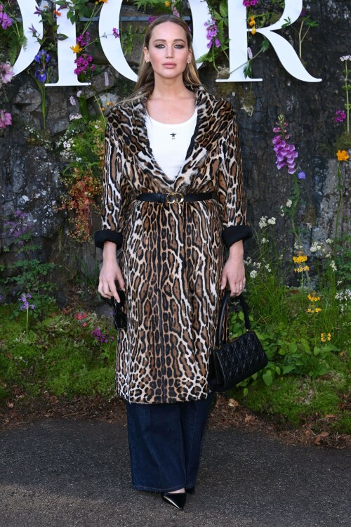 Jennifer Lawrence | Christian Dior Cruise show, Drummond Castle, Crieff, Scotland, UK - 03.06.2024

9 HQ pics: http://kosty555.info/index.php?showtopic=307683

Jennifer Lawrence proves the enduring power of the leopard-print coat in Scotland

An unconventional staple for spring

Jennifer Lawrence brought out her wild side to sit front row at Dior’s Cruise 2025 catwalk show last night, held at Drummond Castle in Perthshire, Scotland.

The actress exuded rich-mom energy in a lavish fur coat in brown, black, and white leopard print. She rolled the outerwear up at the sleeves, revealing the black inside layer, and cinched it at the waist with a black leather belt featuring a golden Christian Dior logo buckle.

Lawrence wore the statement coat over a simple white ribbed Dior tank — emblazoned with the house logo and a little bumblebee at the centre — and deep blue wide-leg jeans. She finished the outfit with black accessories: a chic headband that held down her straight caramel hair, large square shades, a small Lady D-Joy Bag, and pointed-toe pumps. For extra glamour, she added on her go-to diamond stud earrings and her diamond engagement ring from husband Cooke Maroney.

When it came to glam, the No Hard Feelings star and Dior ambassador wore a bronze smoky eye and a glossy cotton-candy pink lip from Dior Beauty.

Lawrence tends to stay true to the French fashion house for grand occasions, and regularly supports the brand and its runway shows around the world.

In February, the actor perfected the Parisian-chic aesthetic in a smoky grey three-piece tweed suit by Dior, which she wore to the brand’s autumn/winter 2024 show in Paris.

And days later, at the Oscars, she walked the red carpet in a strapless black gown with white polka dots all over. The couture piece featured a corseted bodice, an full skirt, and a matching shawl, which the actor rested on her shoulders. Lawrence wore it with Manolo Blahnik pumps and gleaming diamond jewellery by Swarovski.

harpersbazaar.com

#JenniferLawrence